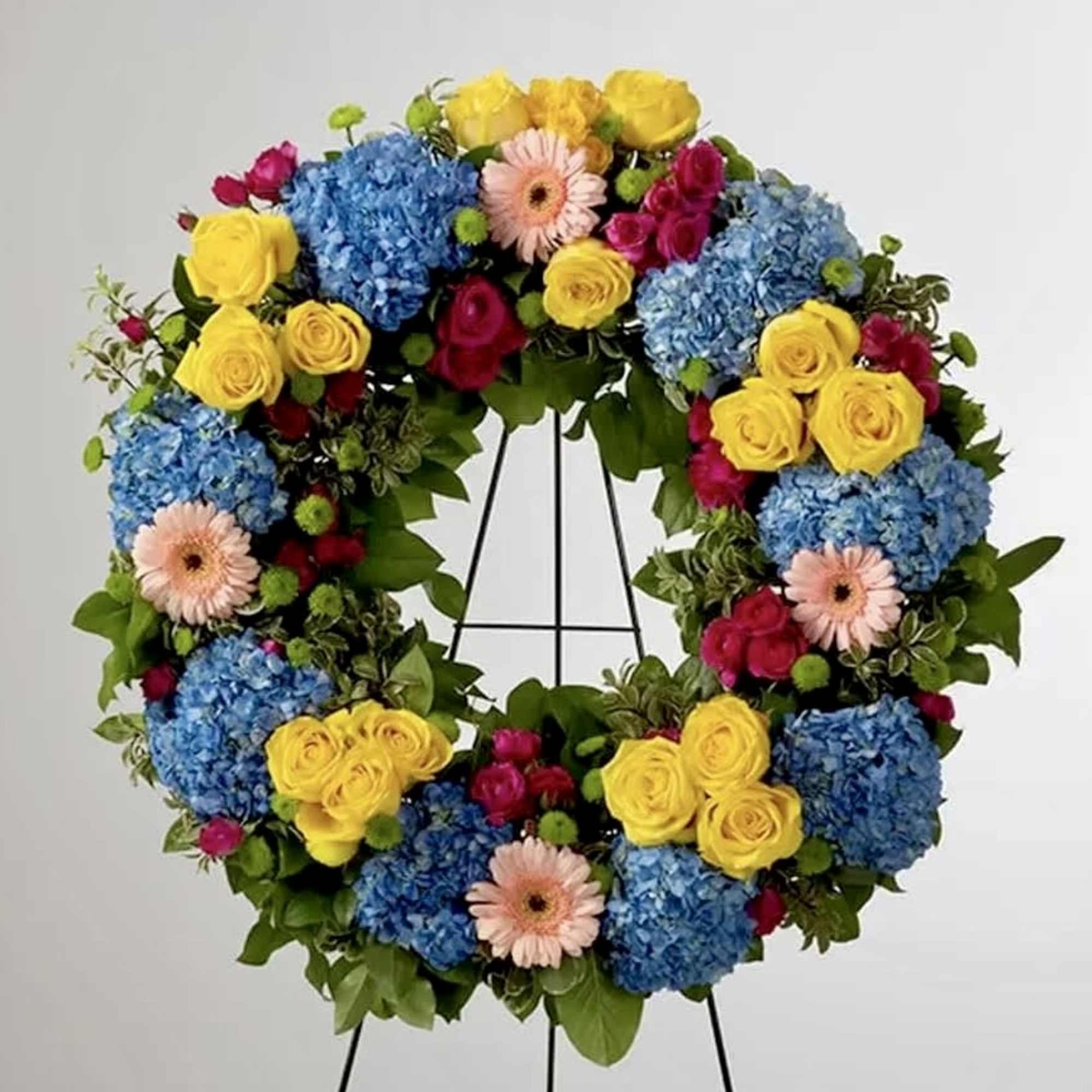This colorful and bright wreath spray is representative of a life lived