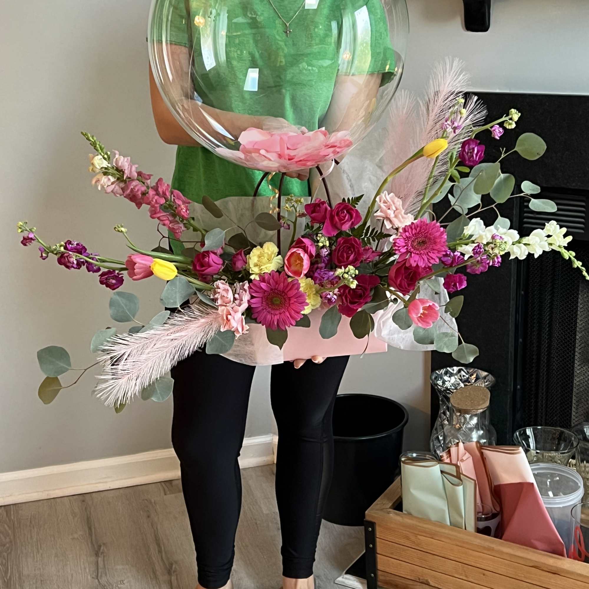 A charming gift bag overflowing with an array of seasonal blooms arranged