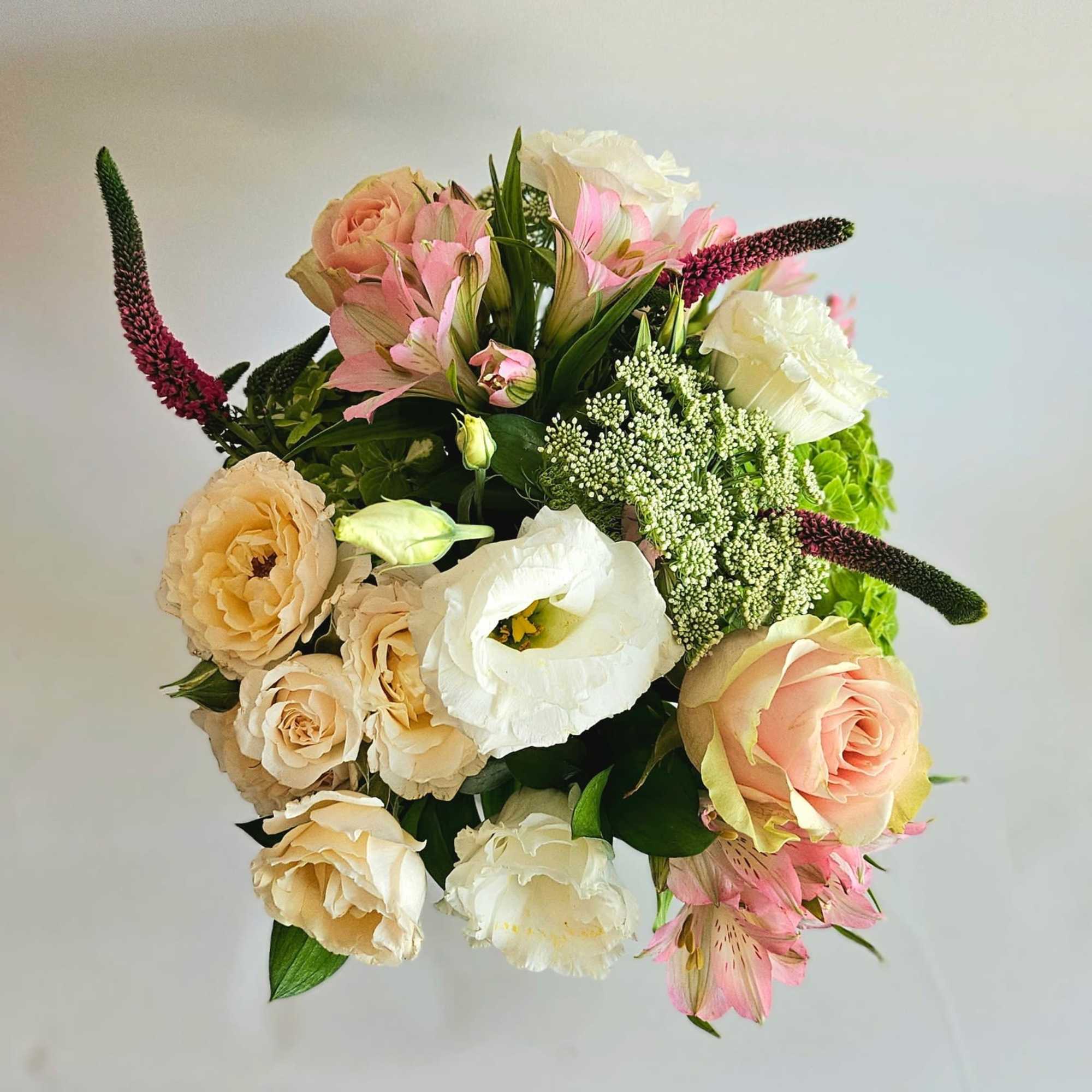A lush and romantic floral arrangement featuring an exquisite blend of roses
