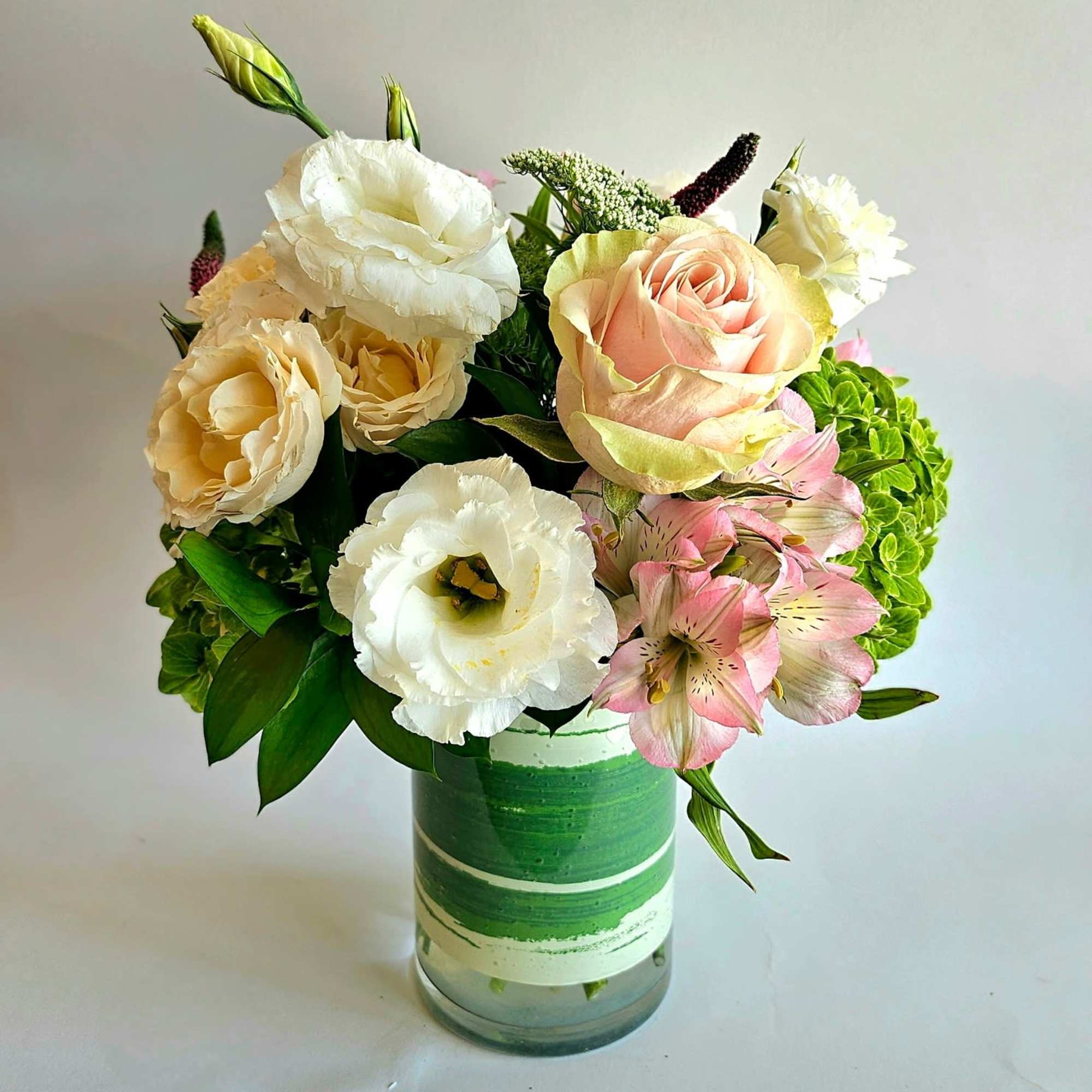 A lush and romantic floral arrangement featuring an exquisite blend of roses