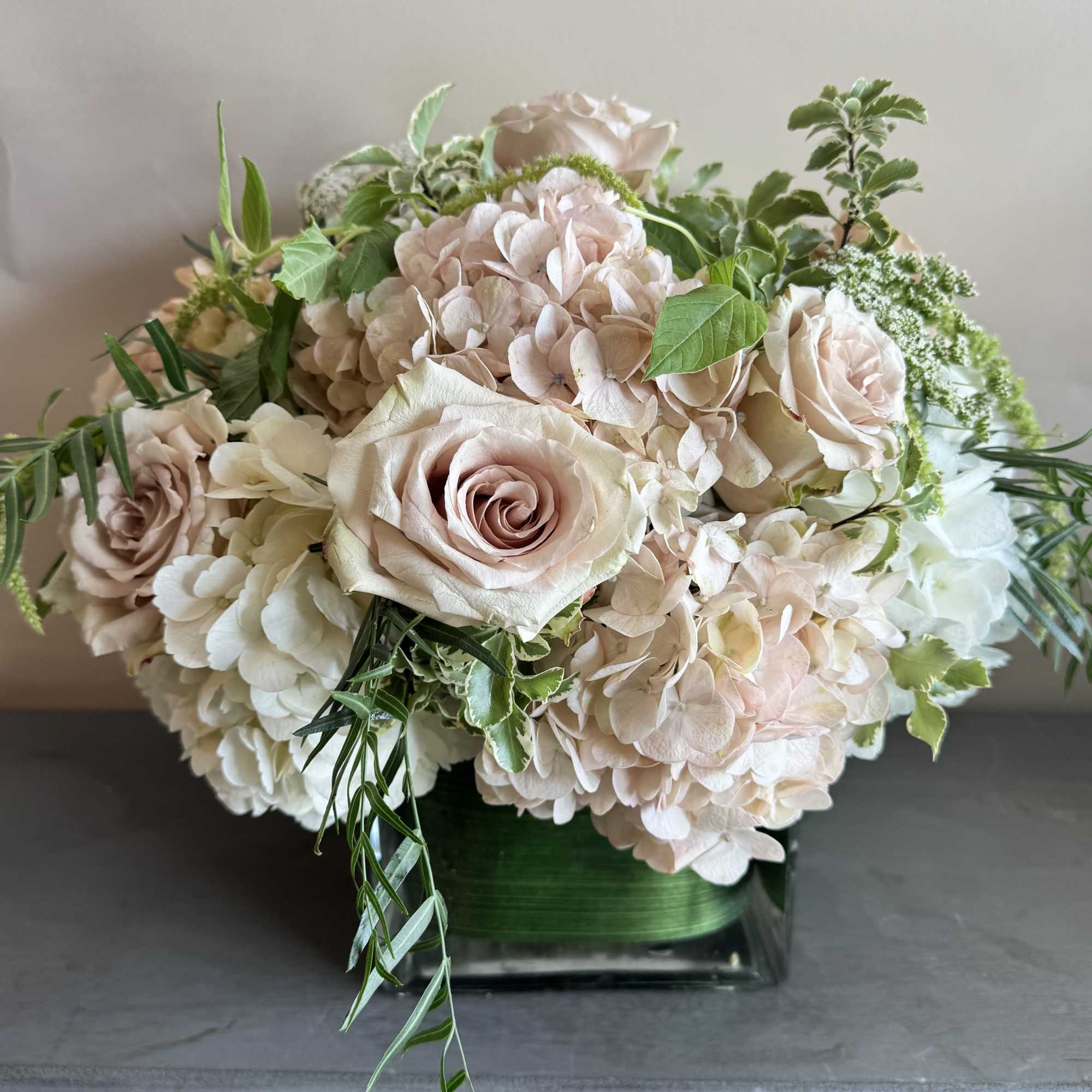 This stunning compact arrangement features a beautiful combination of muted pink roses