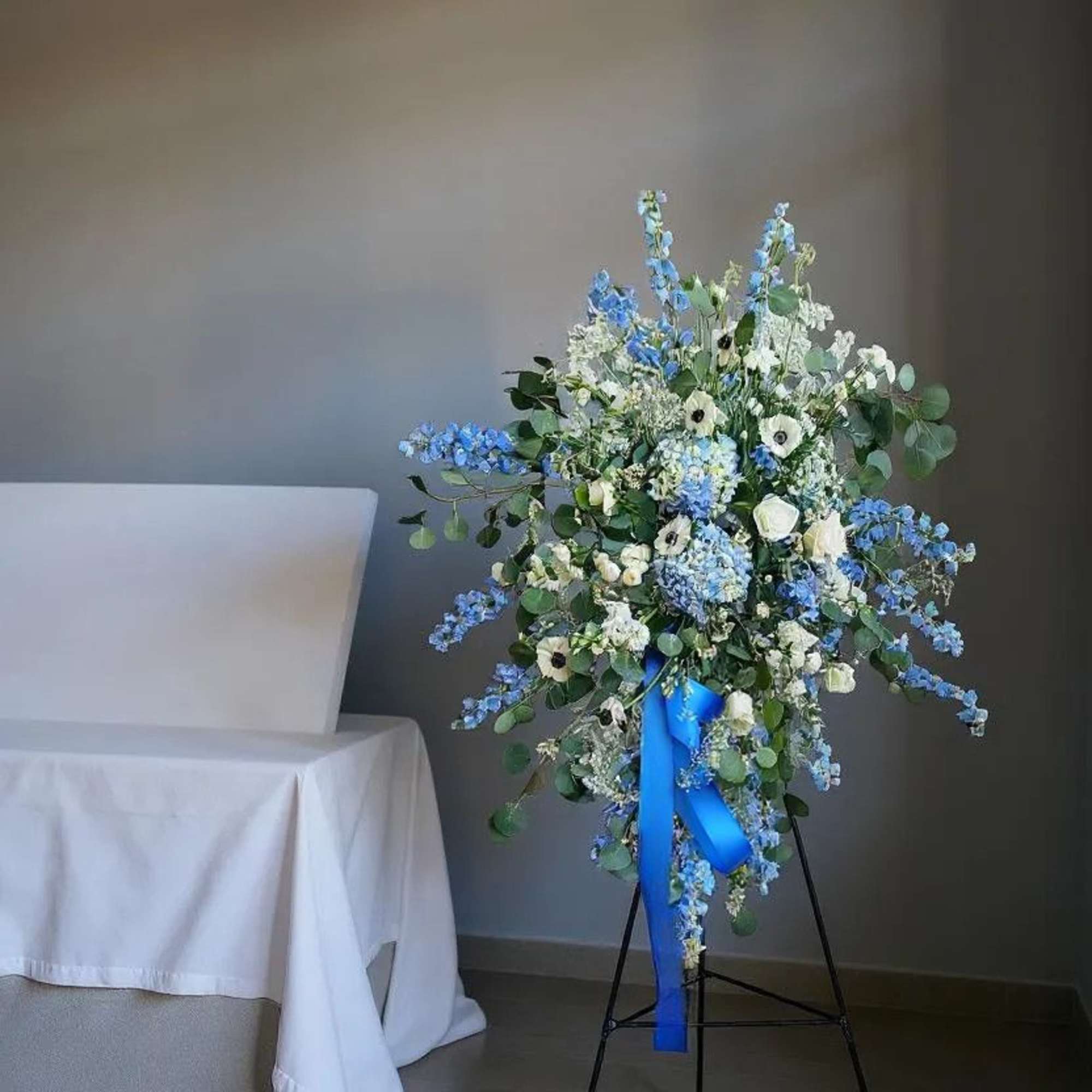 A serene and elegant tribute, the Peaceful Blue Remembrance Spray features a