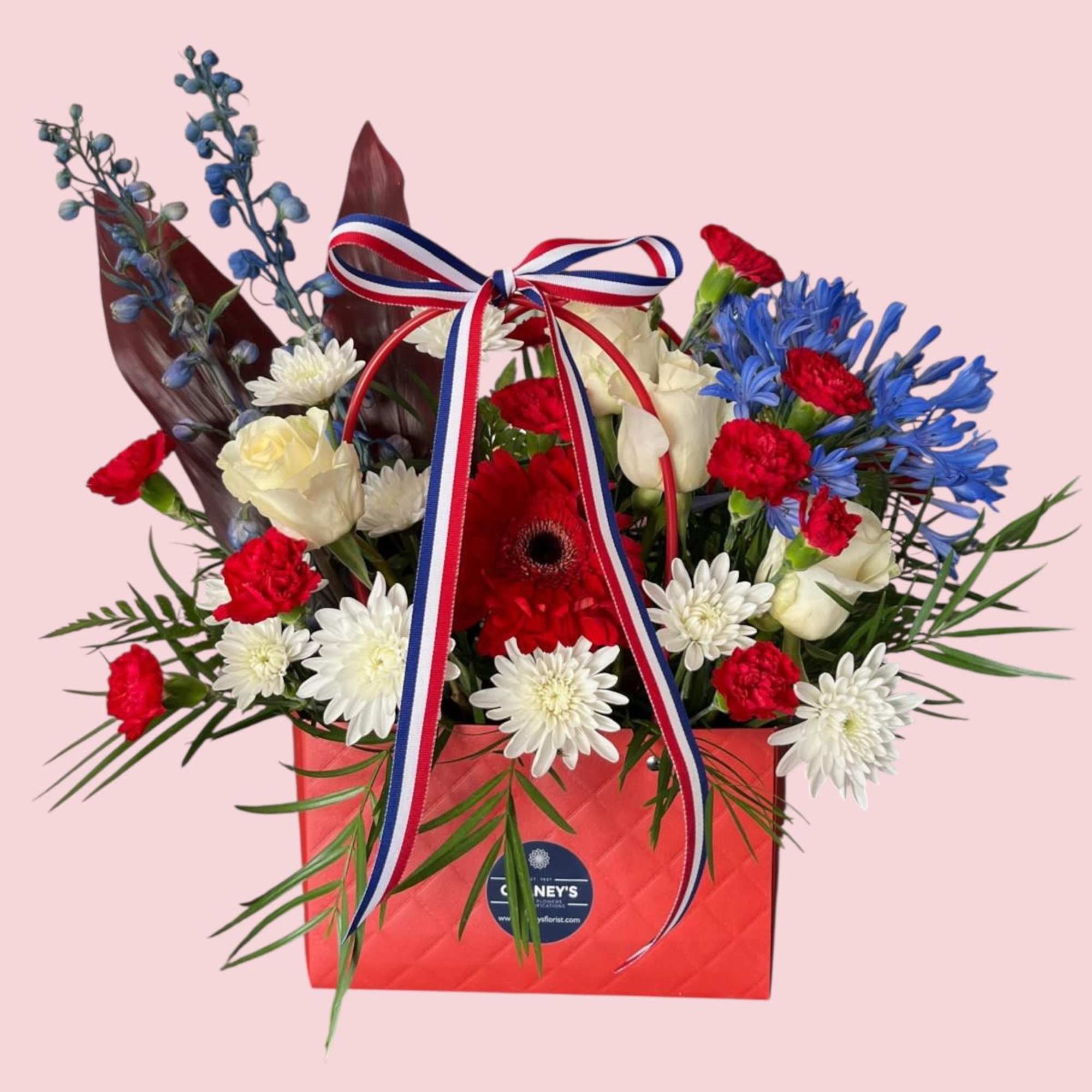 A cute purse in Red, White and Blue with Premium flowers