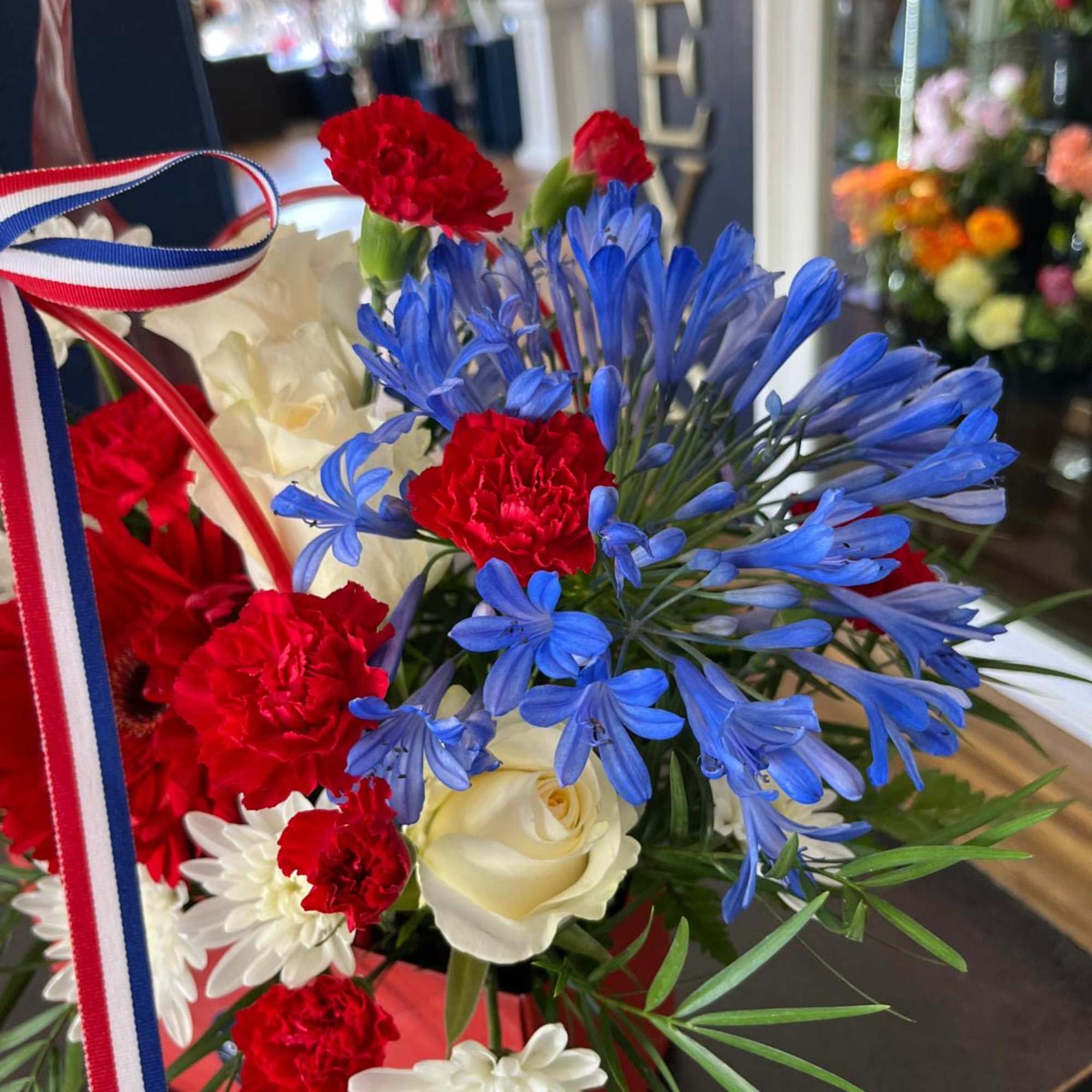 A cute purse in Red, White and Blue with Premium flowers