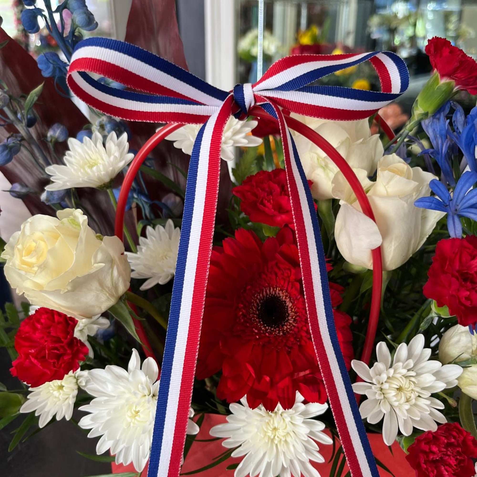 A cute purse in Red, White and Blue with Premium flowers