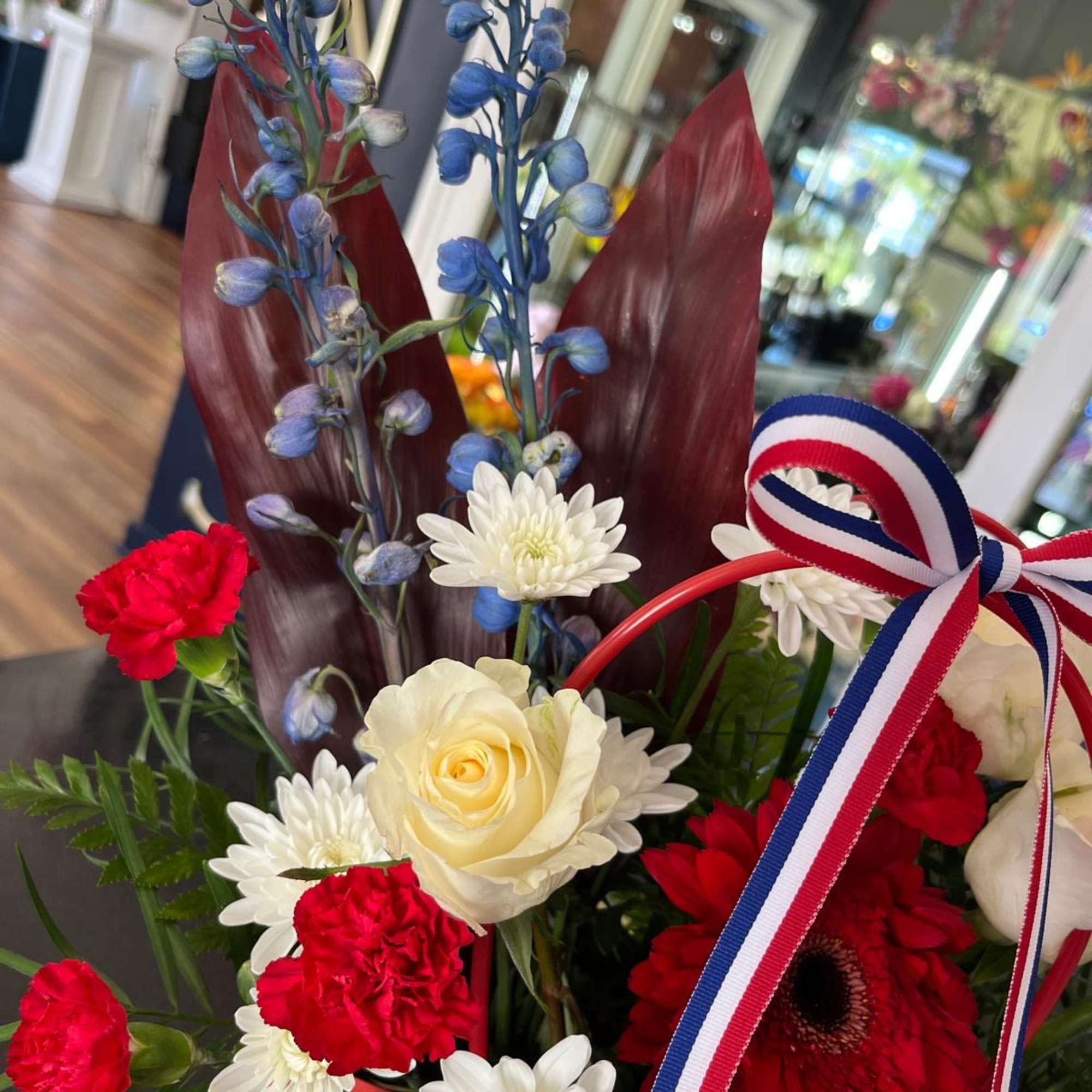 A cute purse in Red, White and Blue with Premium flowers