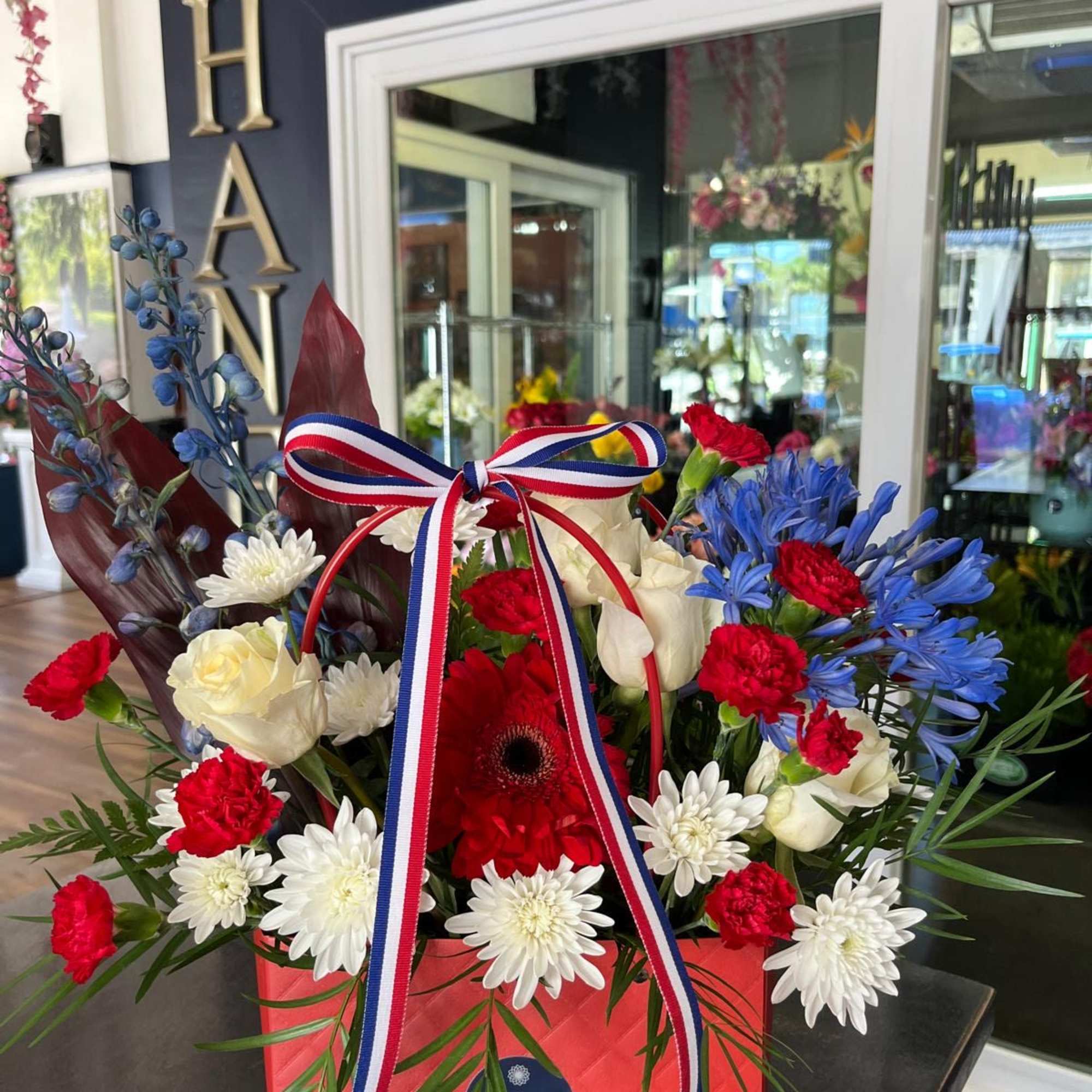 A cute purse in Red, White and Blue with Premium flowers