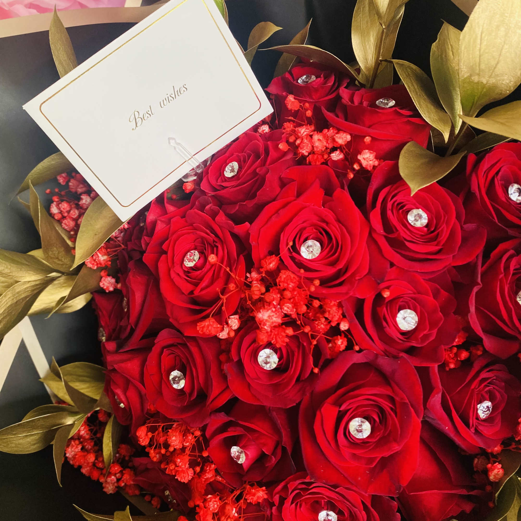 A bouquet made with red &amp; white tones and greenery, topped with