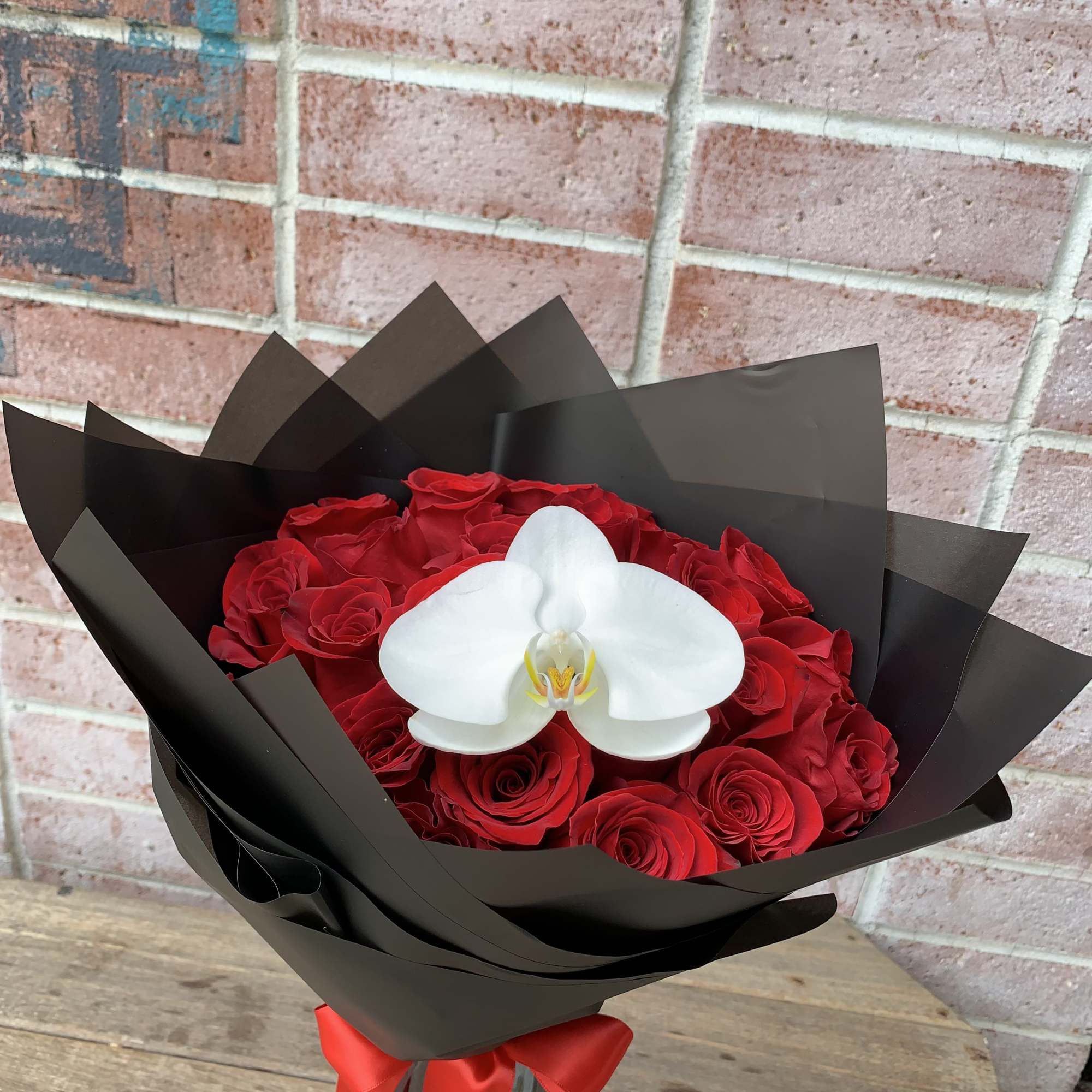 2 Dz of long red roses with one bloom orchid wrap in