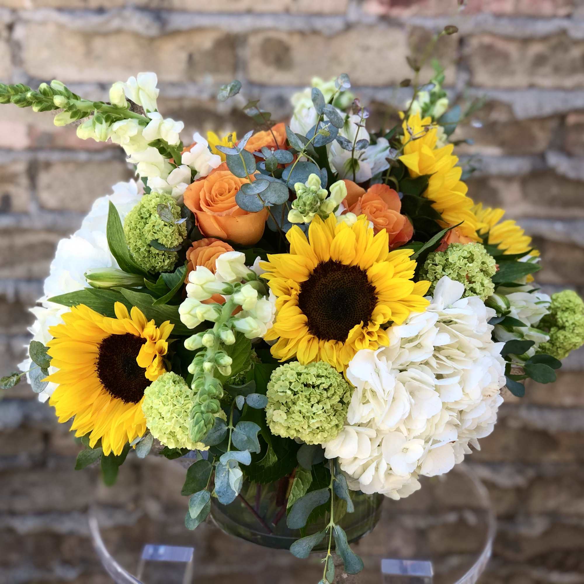 *DELUXE VERSION SHOWN* Sunflowers, Voodoo roses and white hydrangeas are complimented by