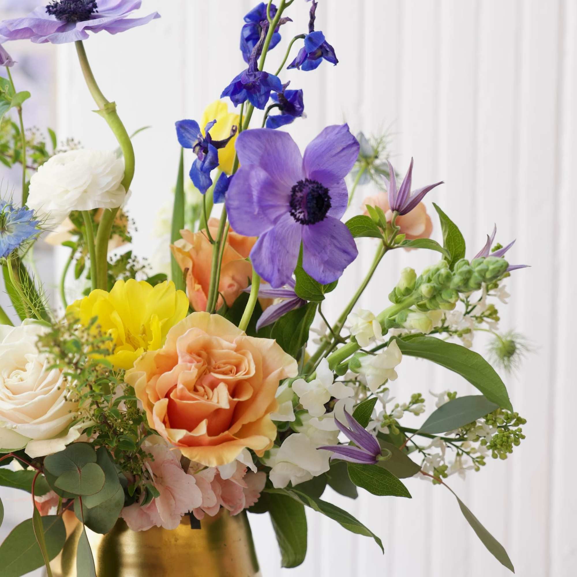 A dreamy blend of delphinium, anemones, roses, and ranunculus—soft hues and bright A dreamy blend of delphinium, anemones, roses, and ranunculus—soft hues and bright