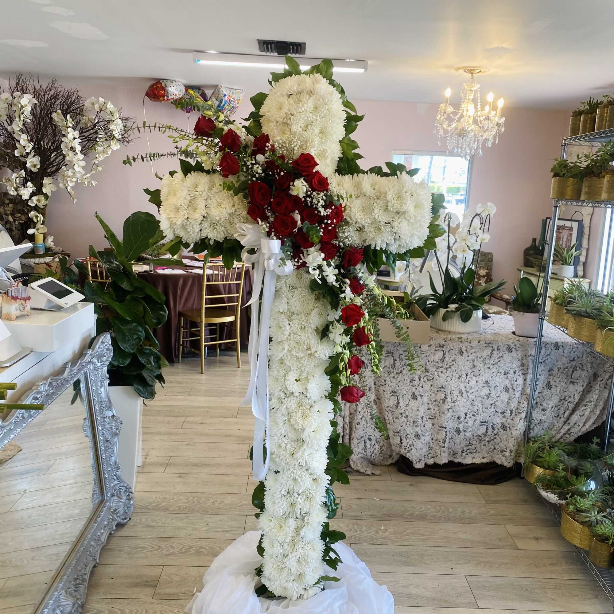 Our premium six-foot floral cross arrangement contains 100 stems of white cushion
