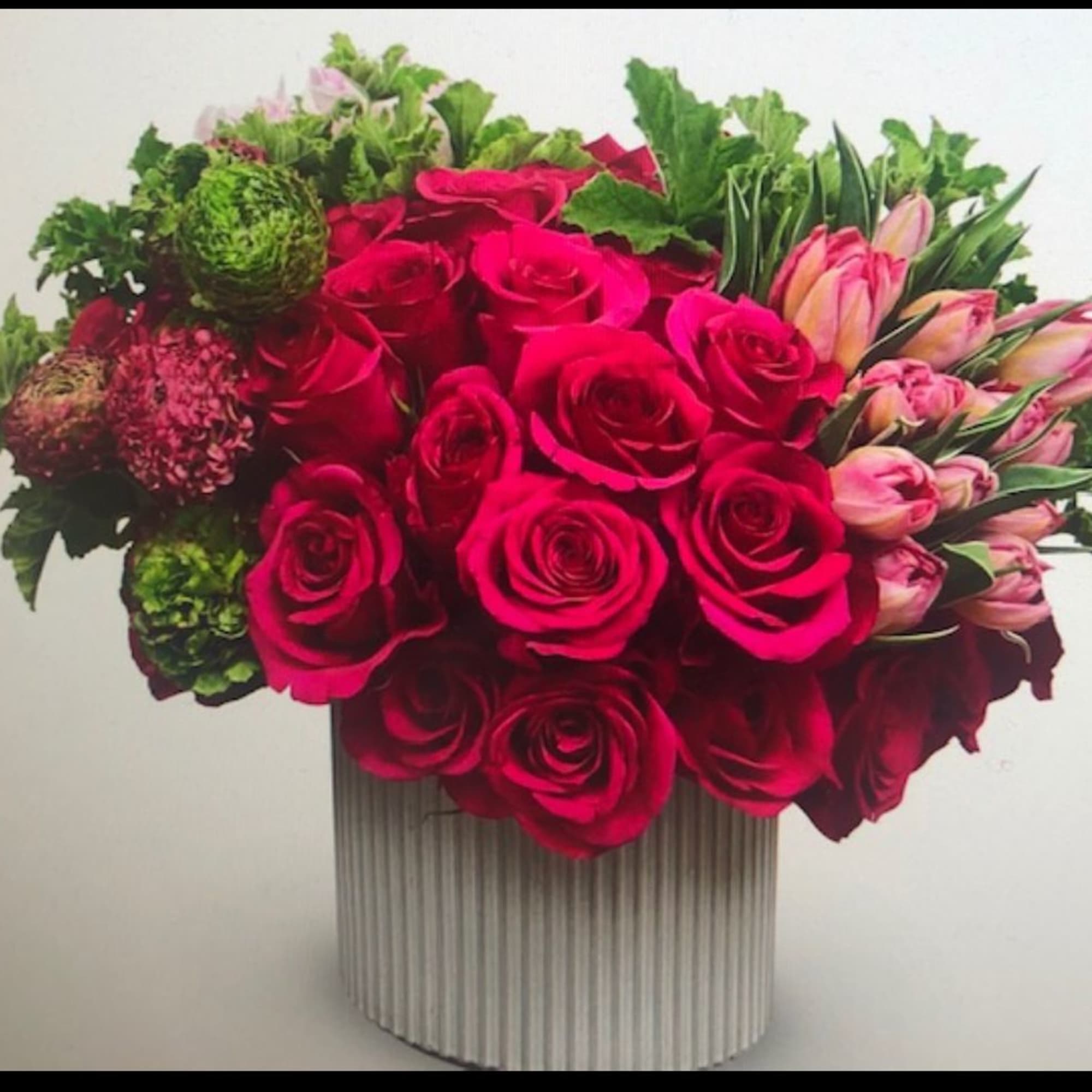 Gorgeous hot pink rose arrangement in a modern ceramic container, green hydrangeas