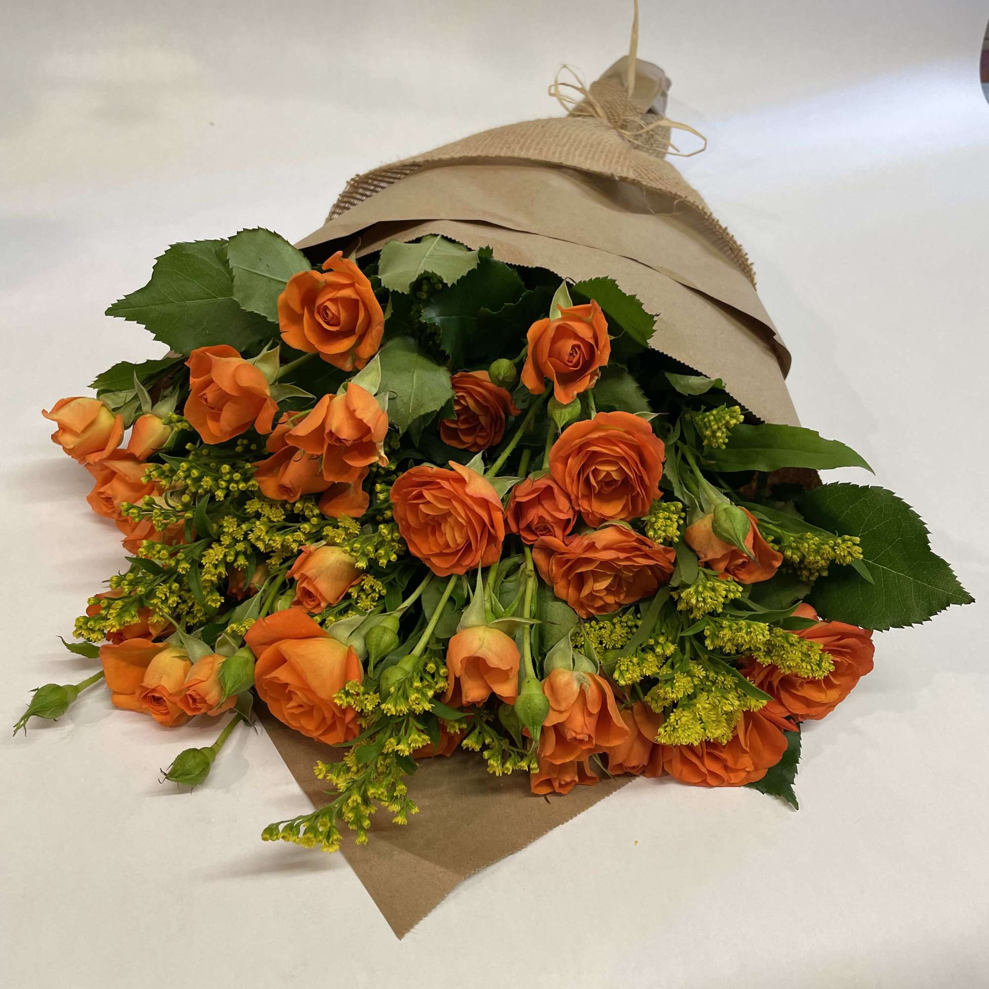 This simple and bright autumn bouquet comes wrapped with brown paper, all