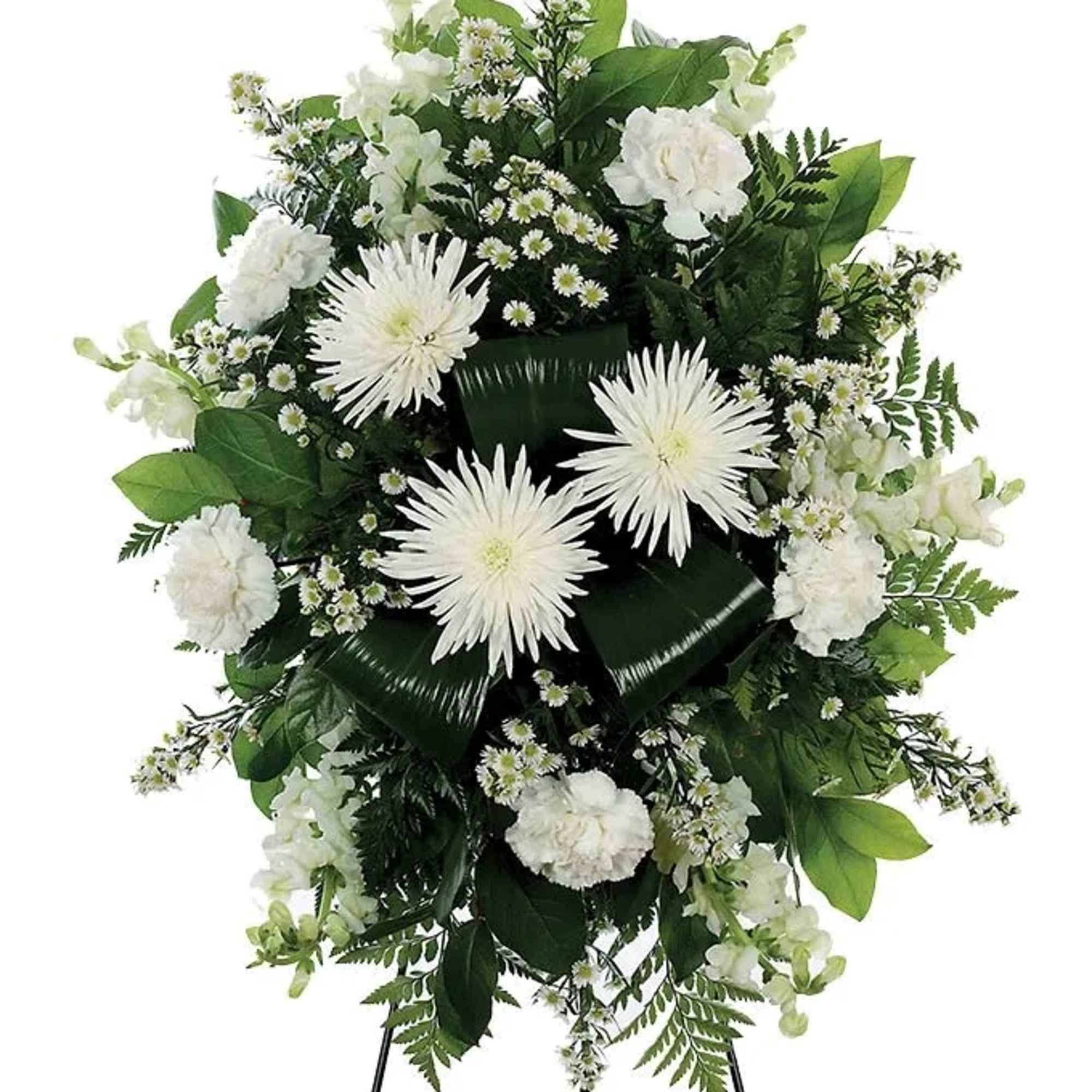 A classic white floral sympathy standing spray, with white carnations, white mums