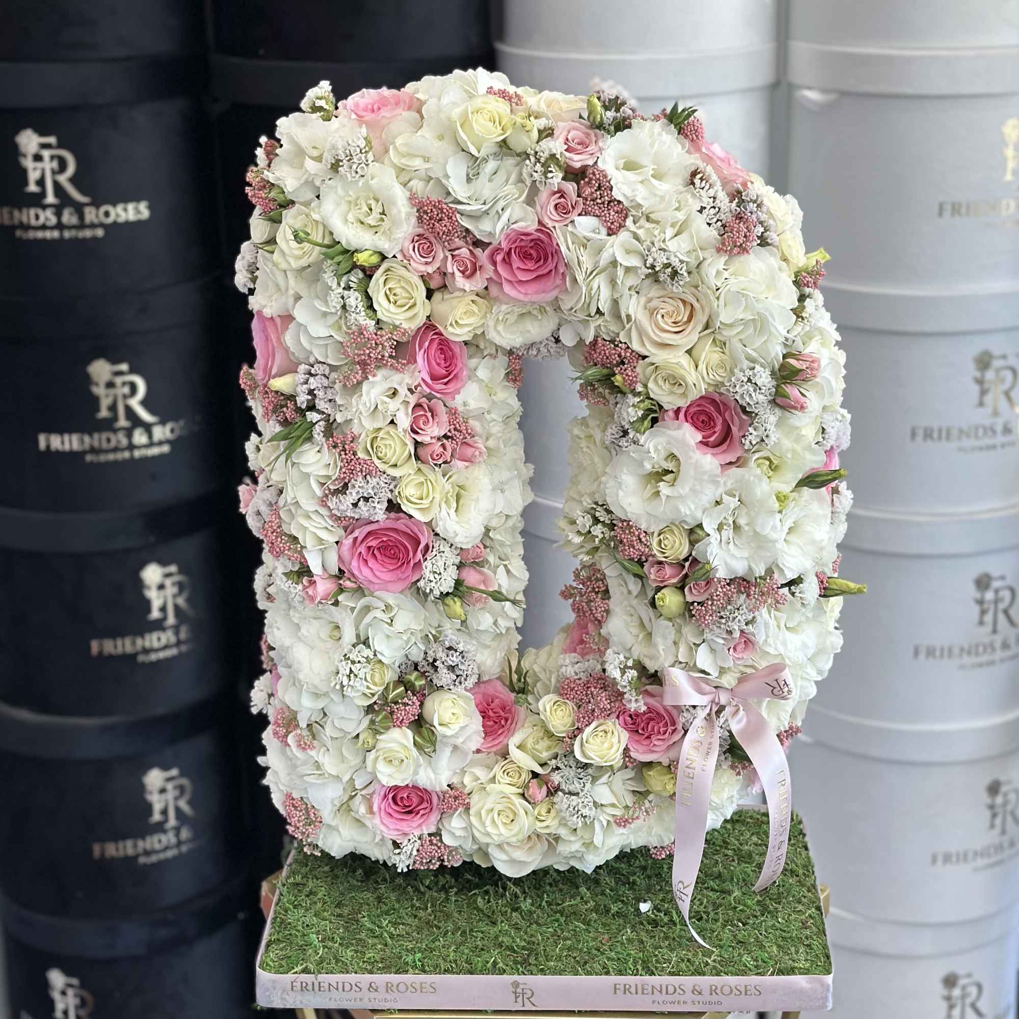 A floristic composition in the shape of the letter M features a