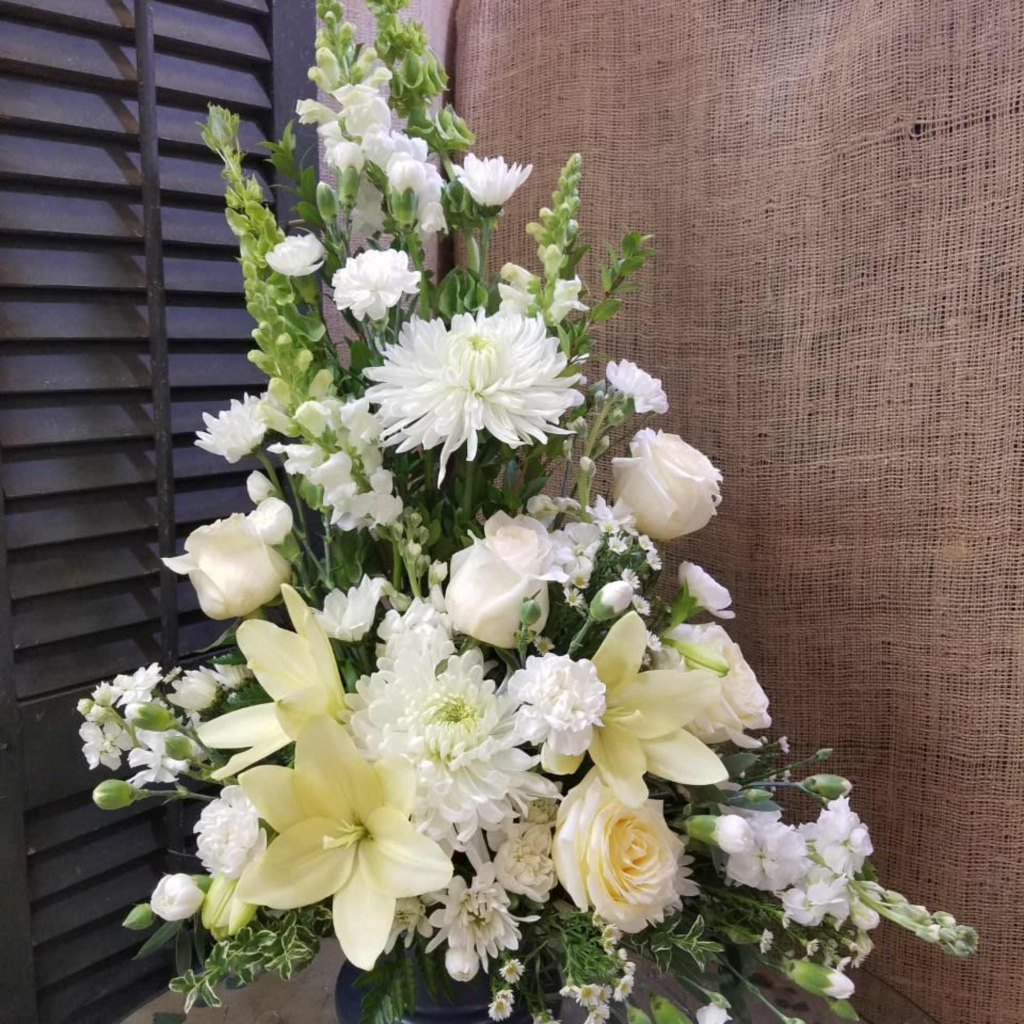 Stunning arrangement in a pedestal container featuring gorgeous white flowers of all Stunning arrangement in a pedestal container featuring gorgeous white flowers of all
