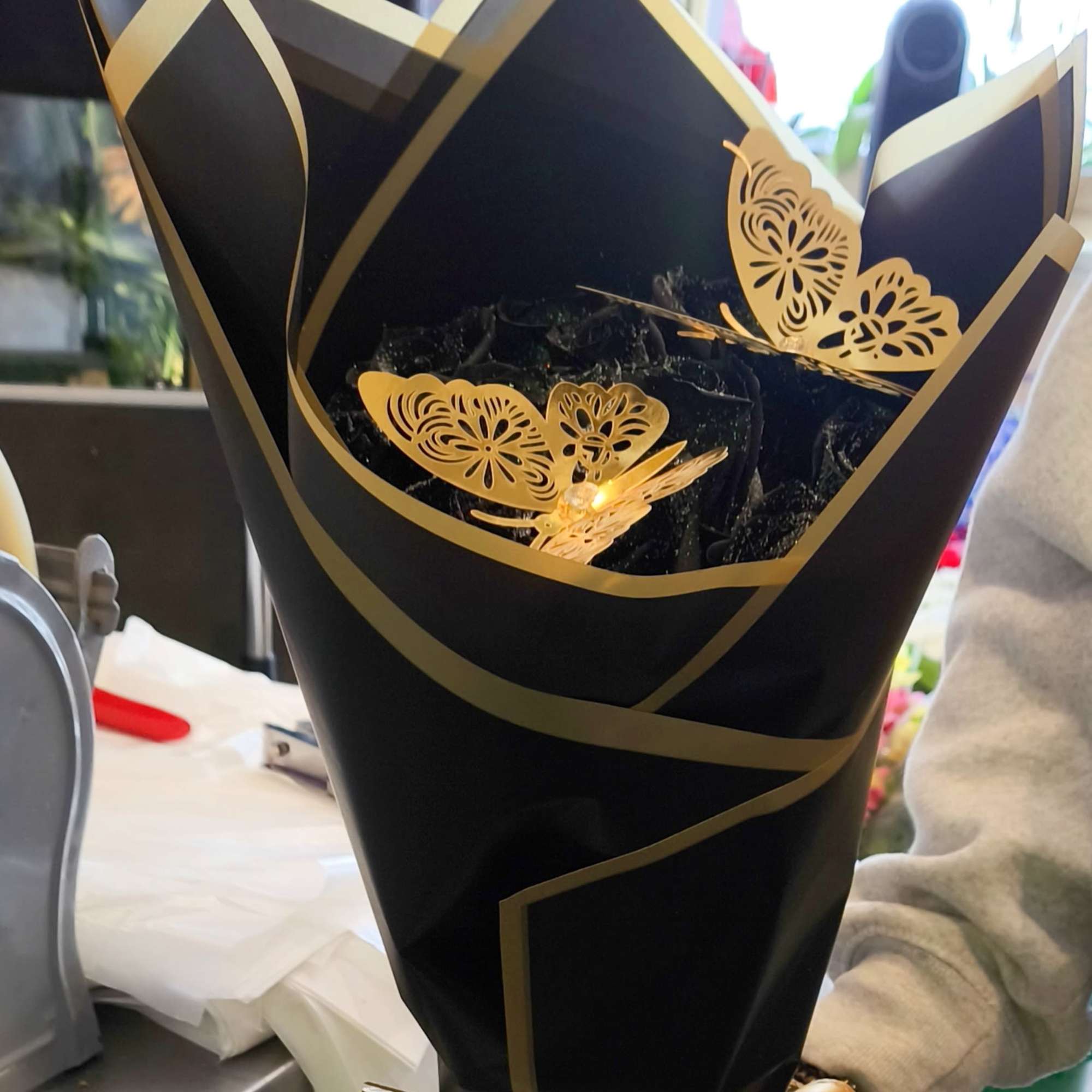 We design a dozen black roses with silver glitter wrapped in black