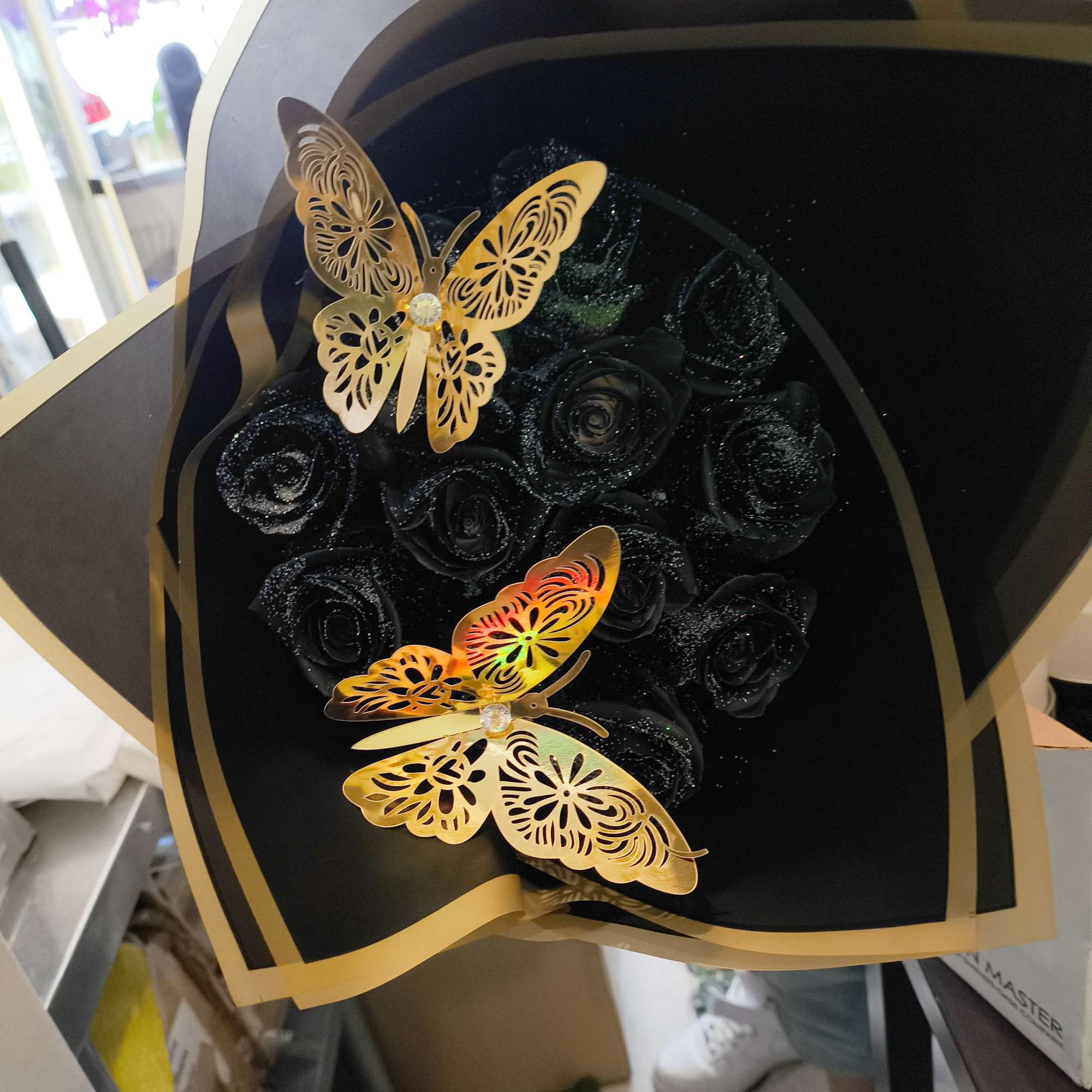 We design a dozen black roses with silver glitter wrapped in black