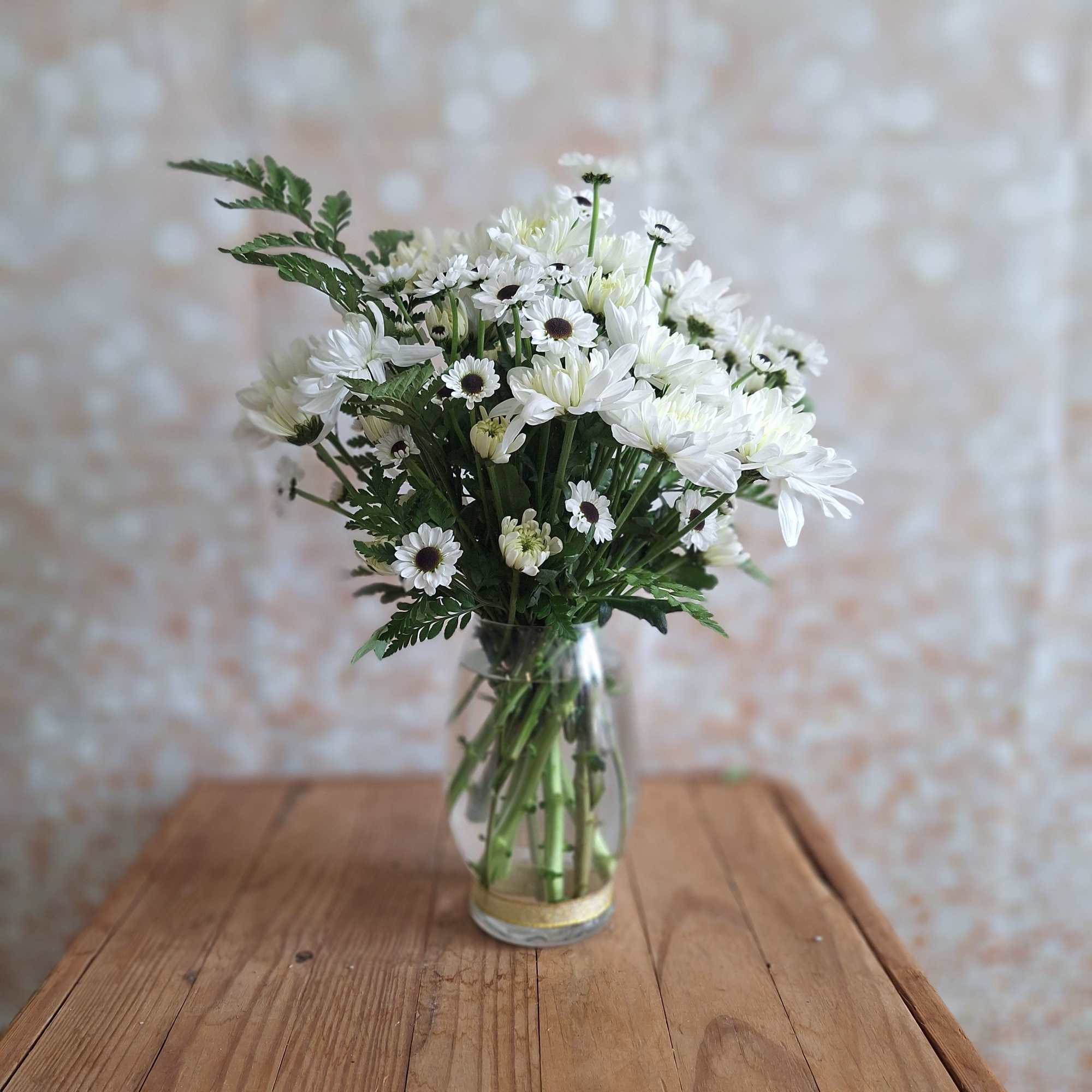 A sparkling glass vase overflowing with sun-kissed daisies is a sure-fire way
