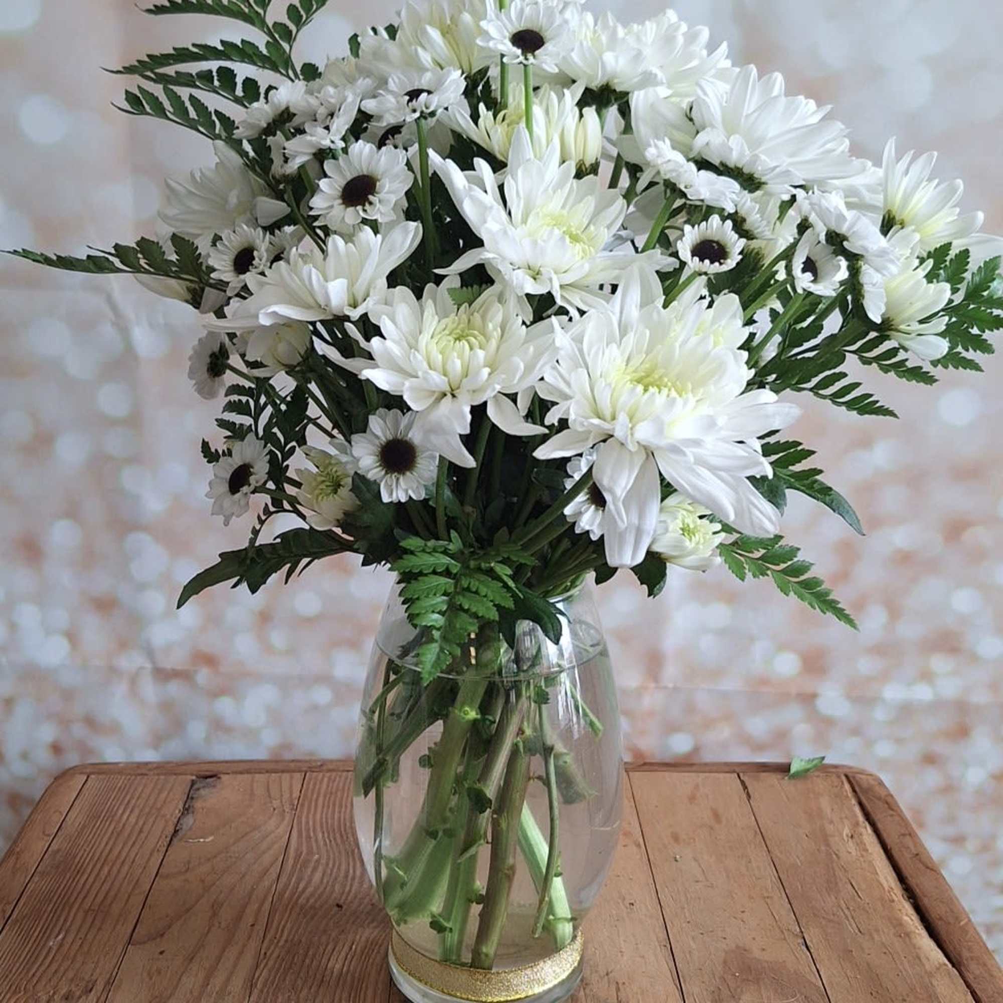 A sparkling glass vase overflowing with sun-kissed daisies is a sure-fire way