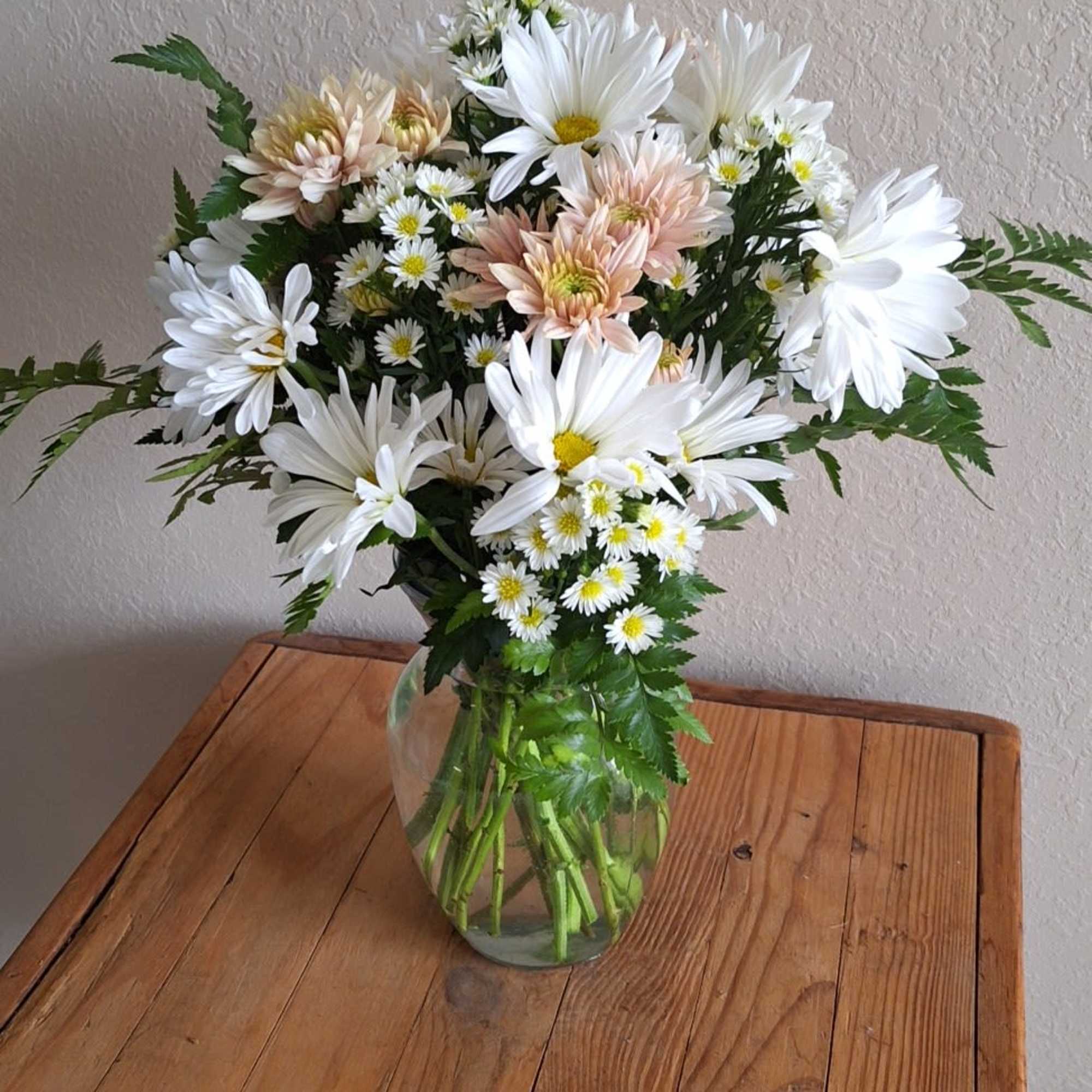 A sparkling glass vase overflowing with sun-kissed daisies is a sure-fire way