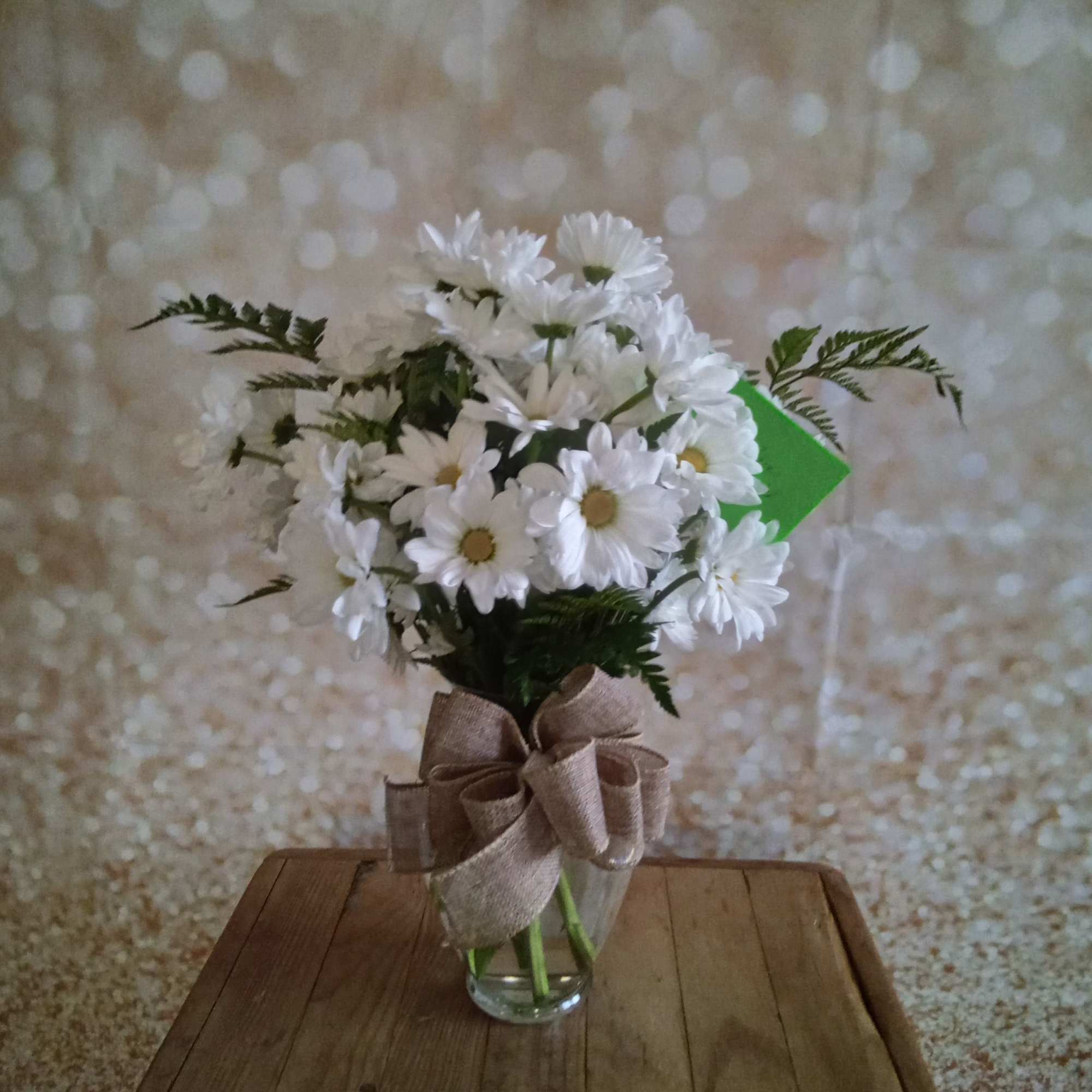 A sparkling glass vase overflowing with sun-kissed daisies is a sure-fire way