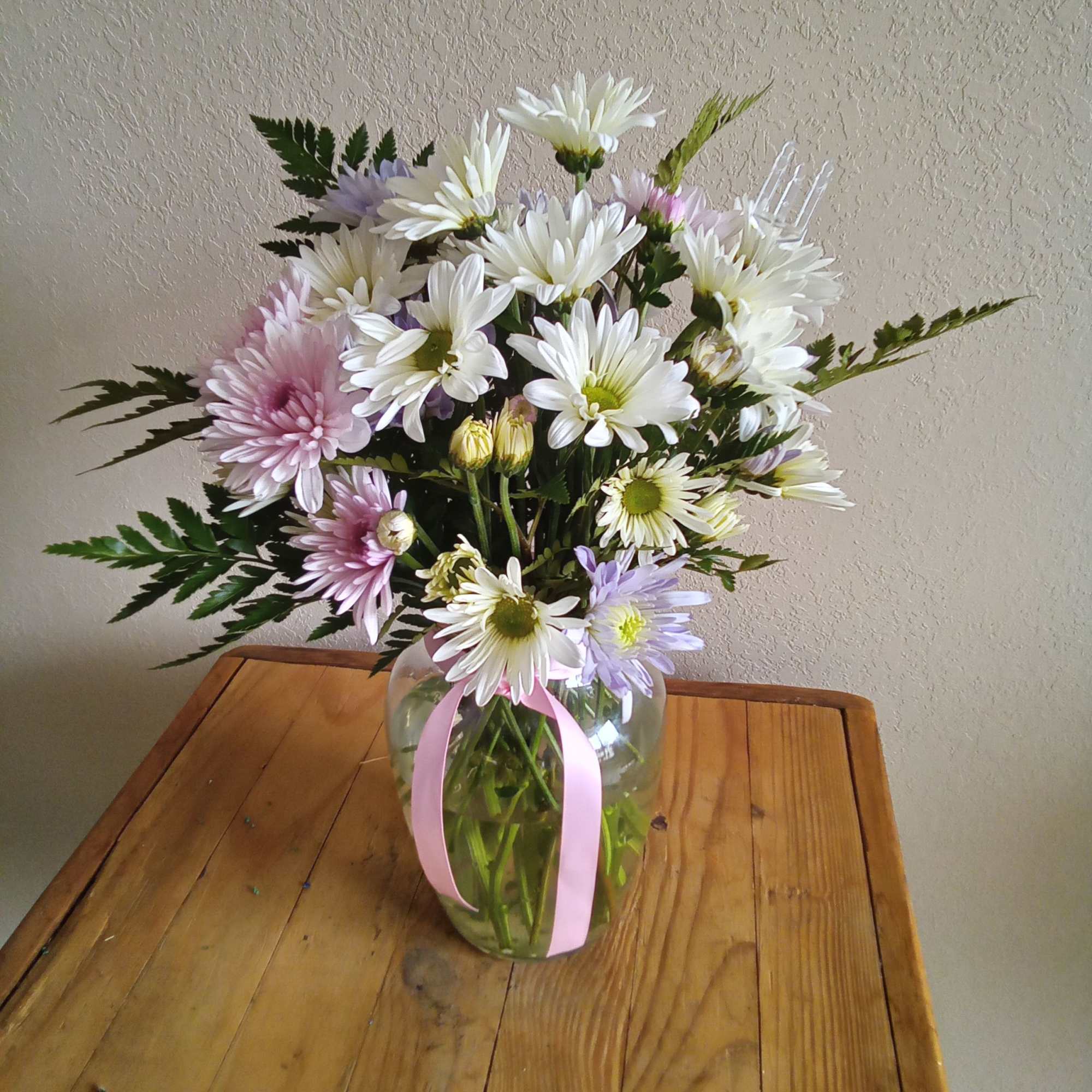 A sparkling glass vase overflowing with sun-kissed daisies is a sure-fire way