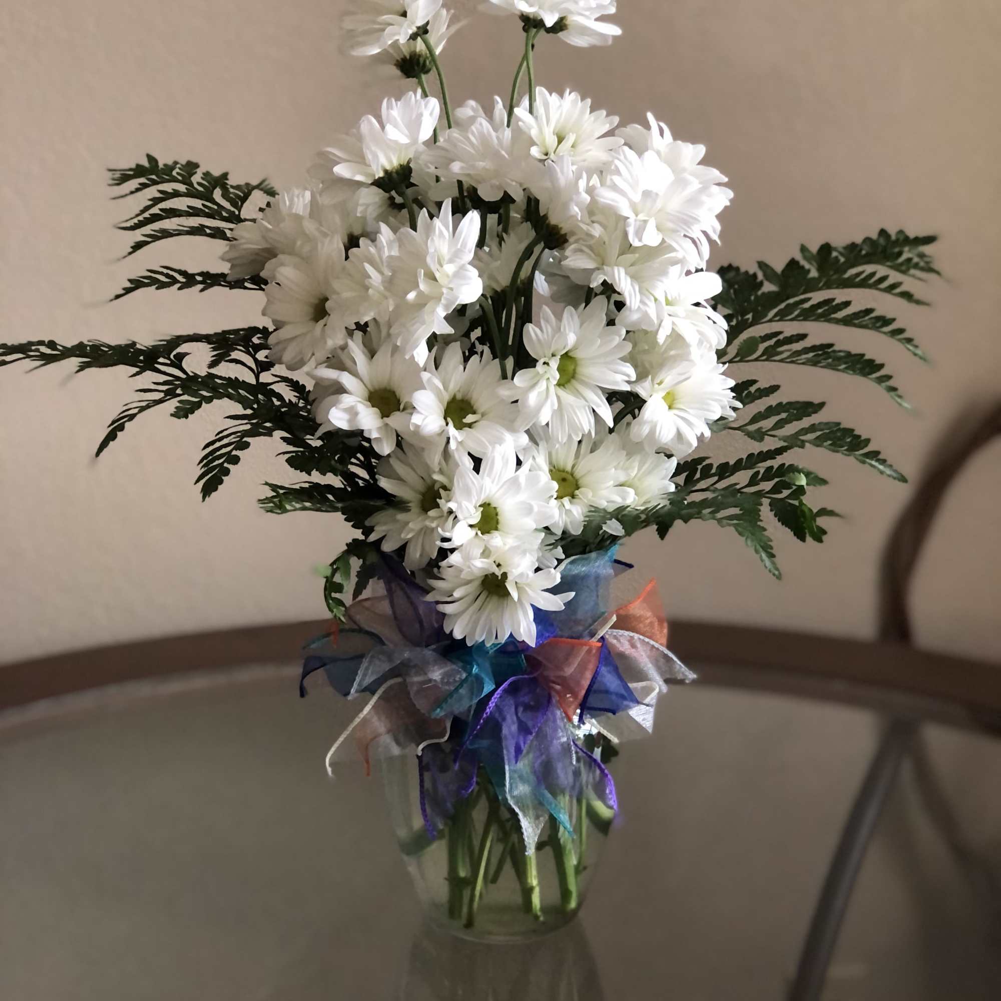 A sparkling glass vase overflowing with sun-kissed daisies is a sure-fire way