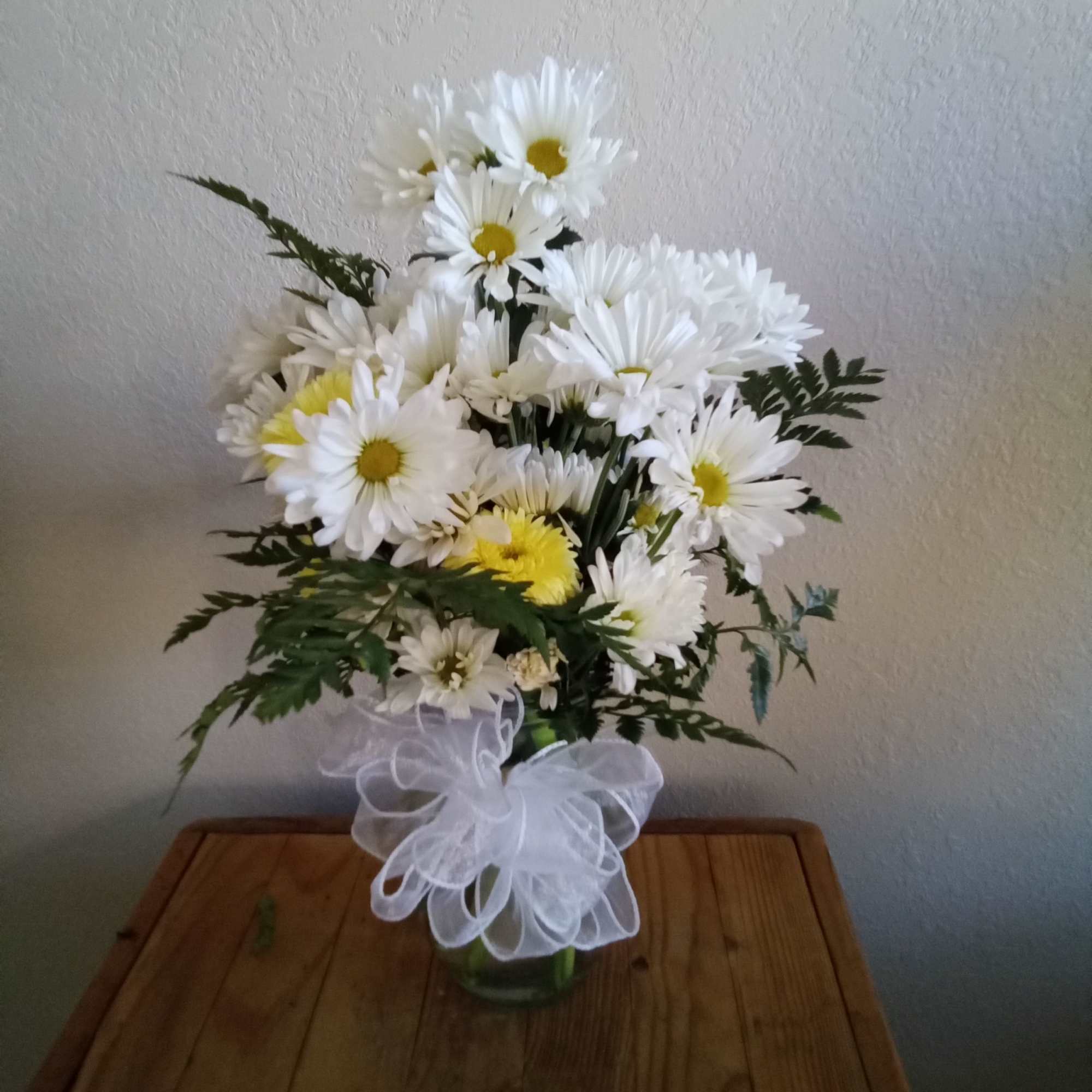 A sparkling glass vase overflowing with sun-kissed daisies is a sure-fire way