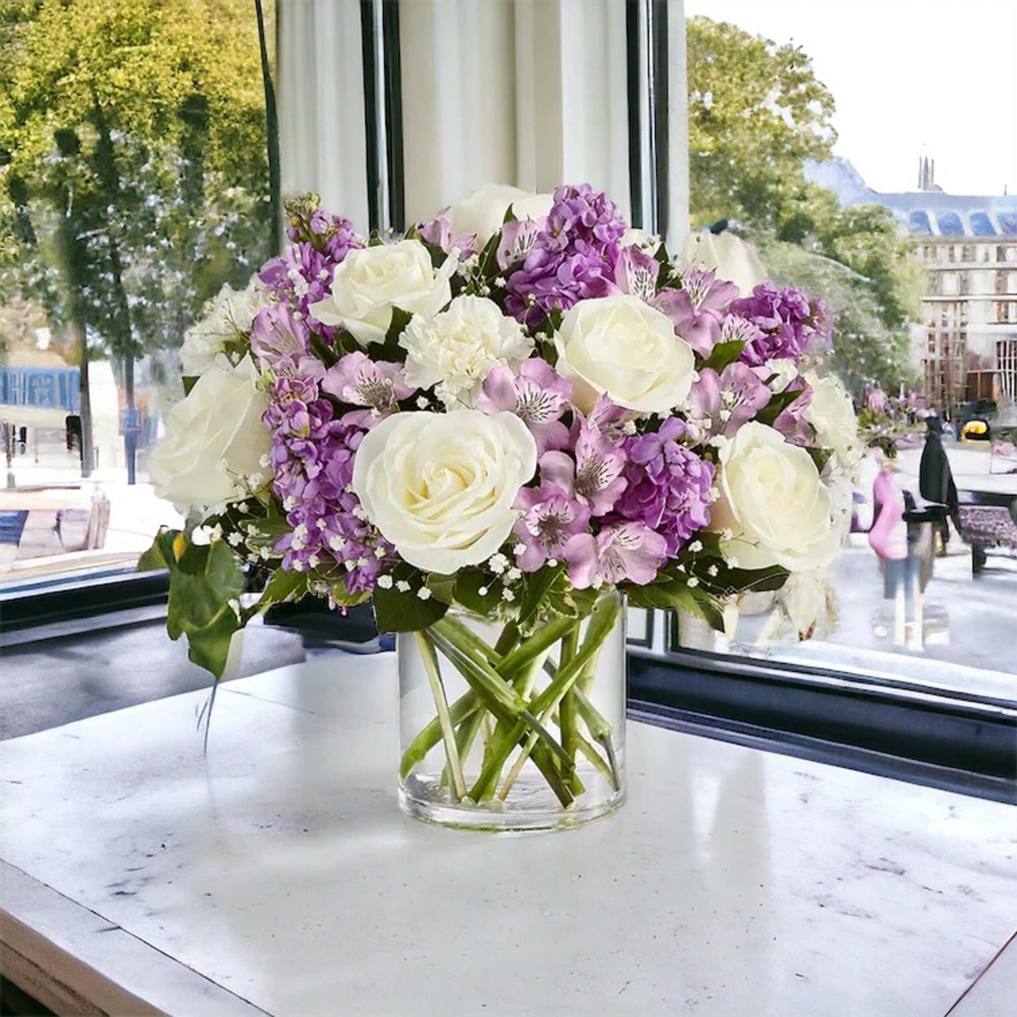 White roses, white carnations, lavender Astro, purple stock, baby&rsquo; breath and greenery