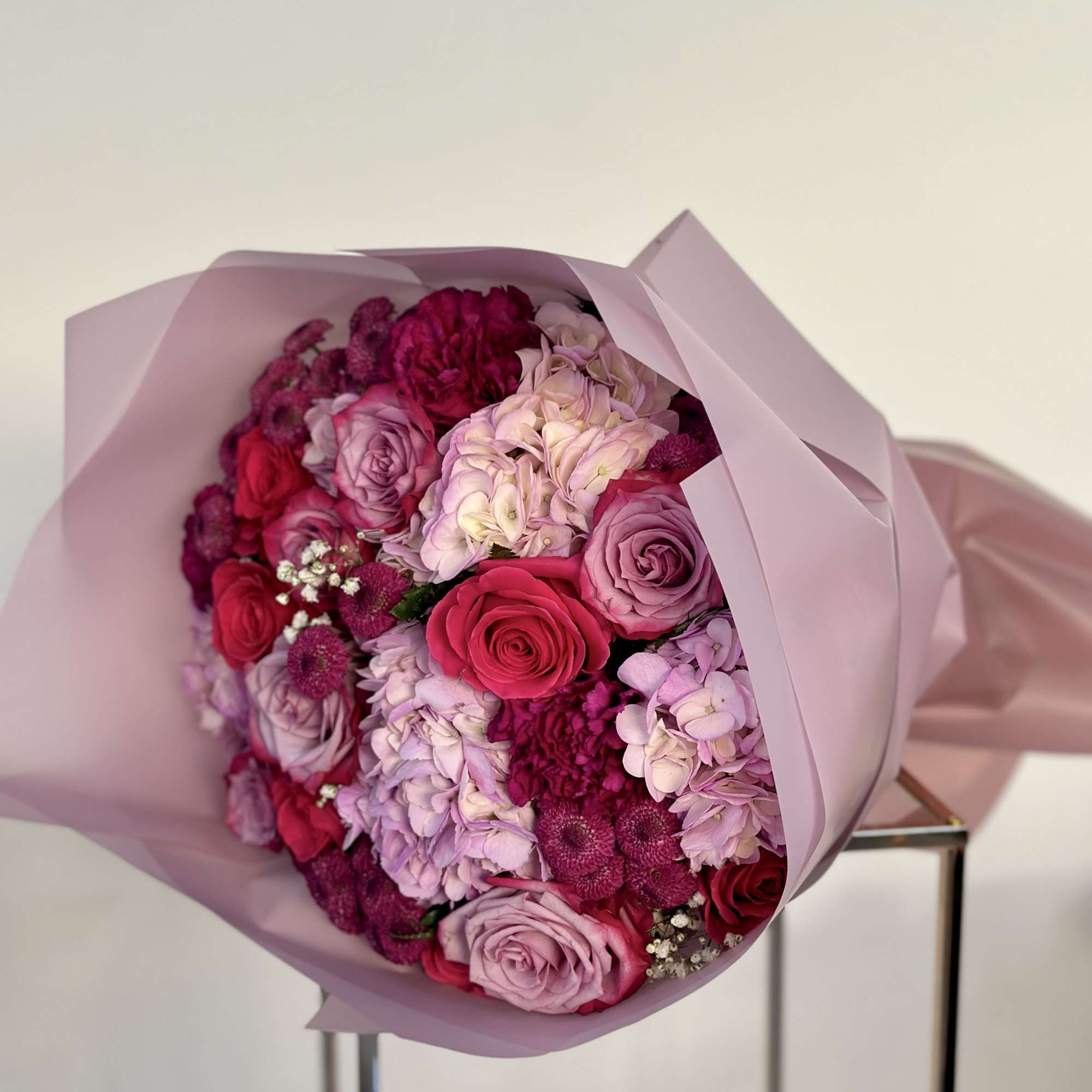 This captivating bouquet is a delightful fusion of enchanting purple hues. It