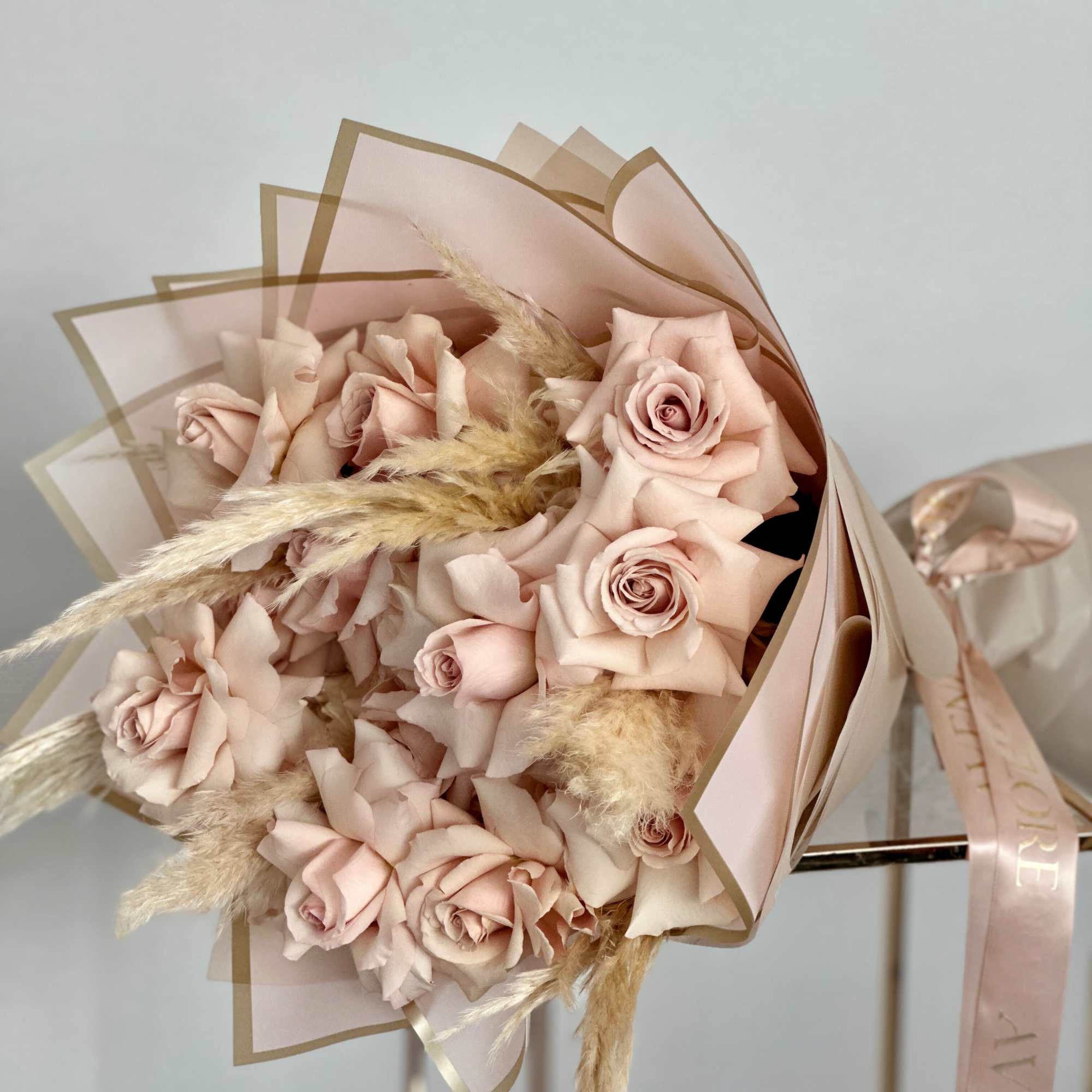 This bouquet features a mesmerizing array of soft beige roses, each one