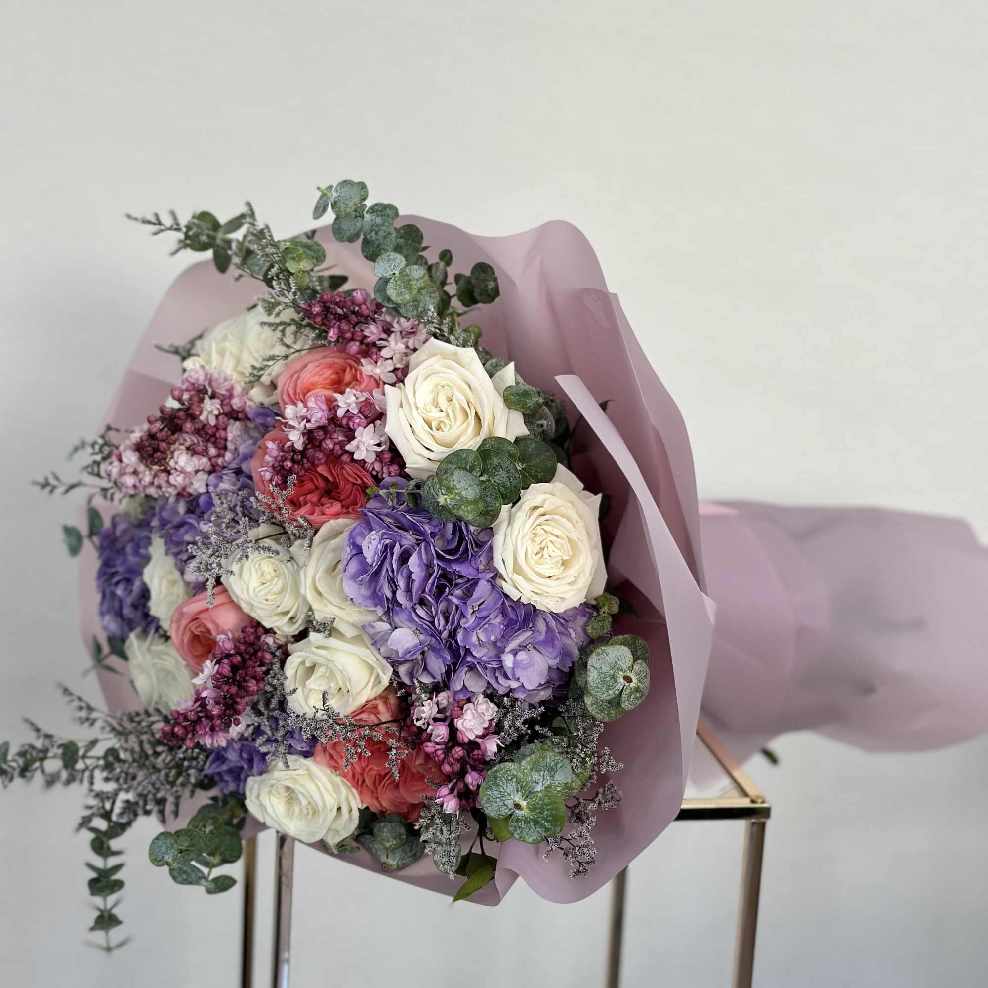 Indulge in the elegance of this bouquet, where pristine white roses, vibrant