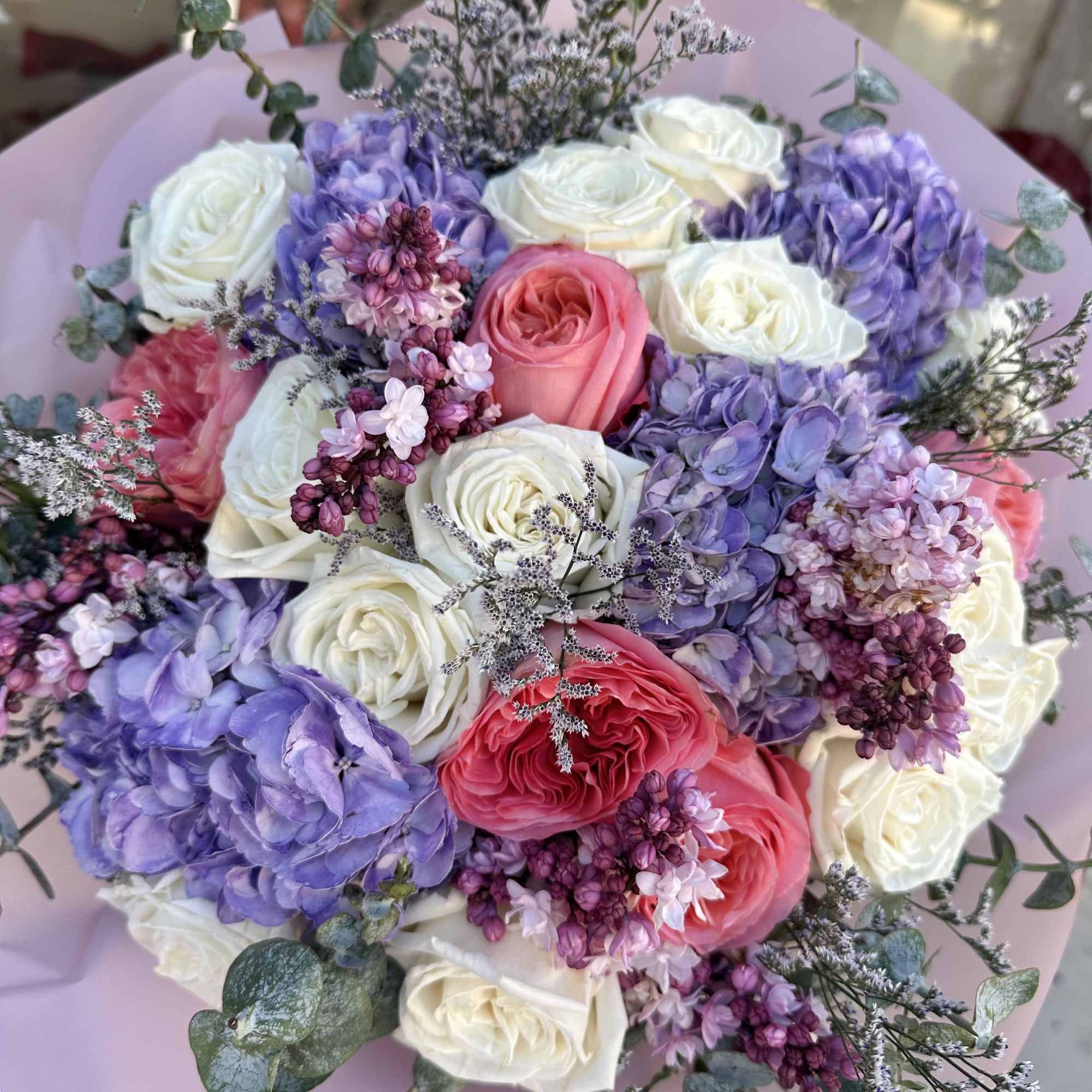 Indulge in the elegance of this bouquet, where pristine white roses, vibrant