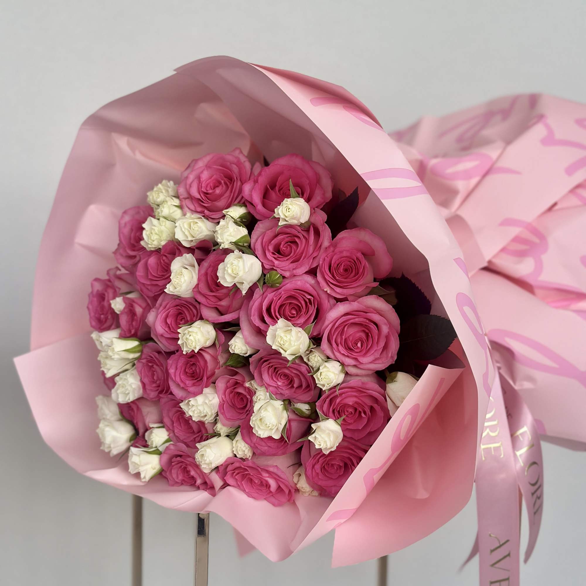 This beautiful bouquet of pink roses and white spray roses is a