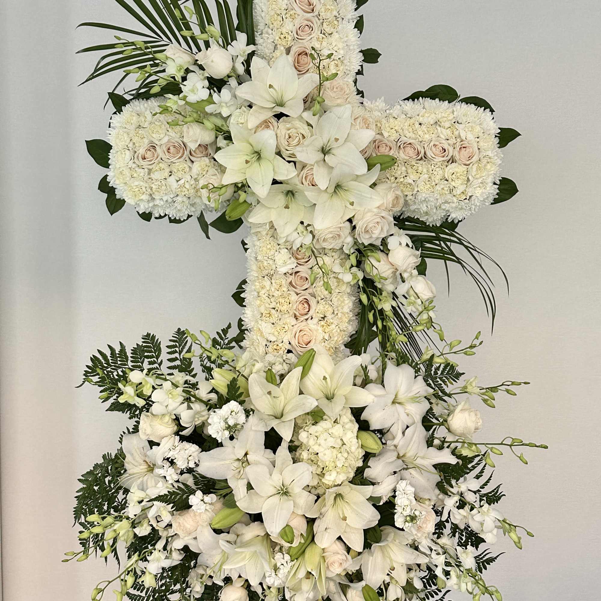 Embodying purity and serenity, this funeral wreath cross is meticulously crafted from