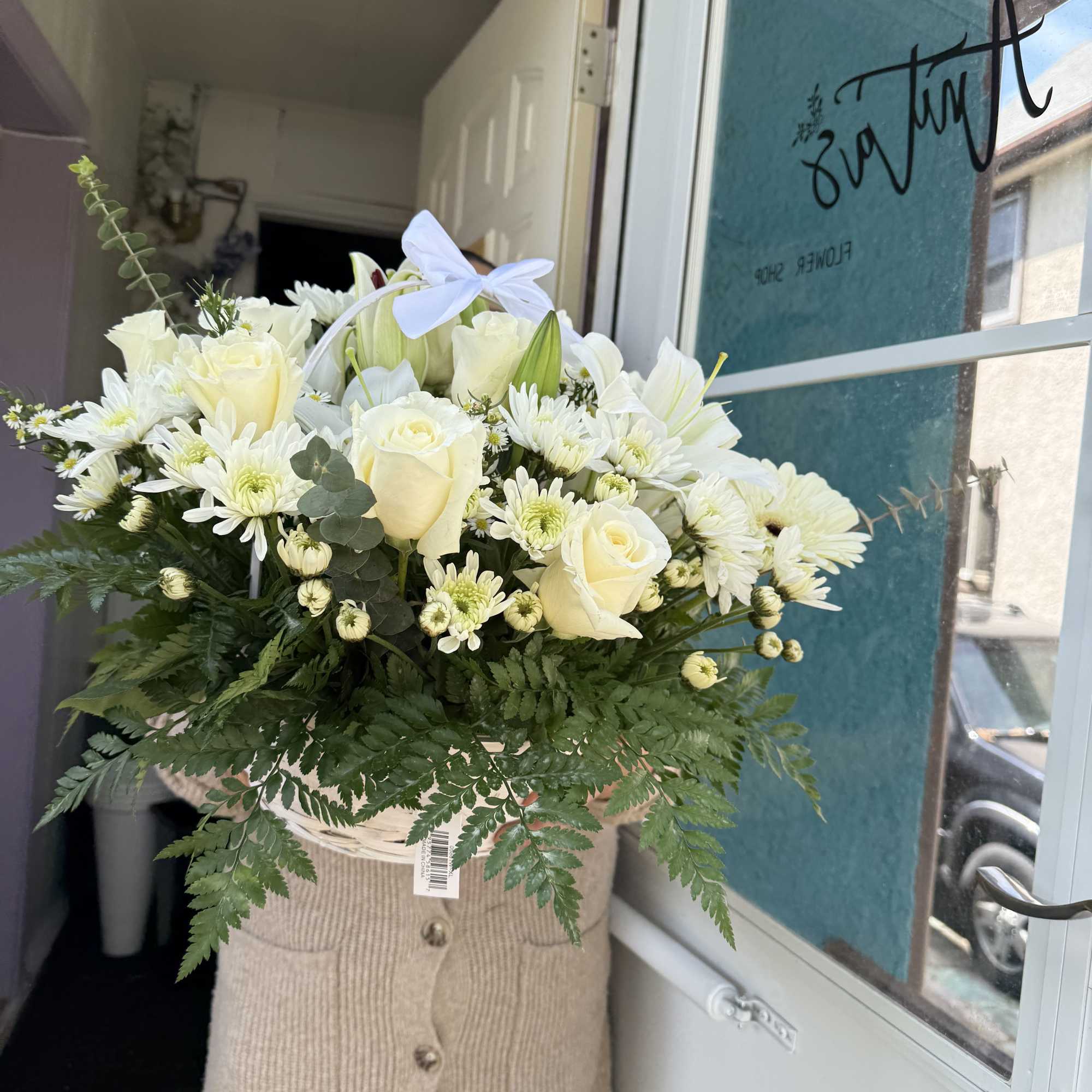 White Basket with different flowers in color white and greens. If you