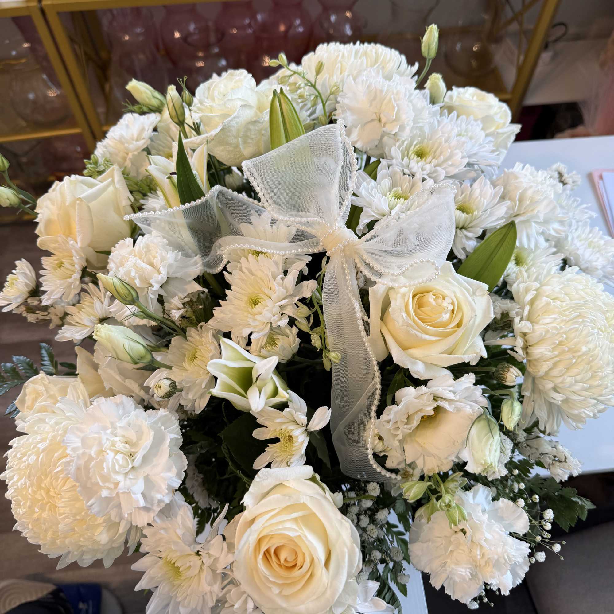 White Basket with different flowers in color white and greens. If you