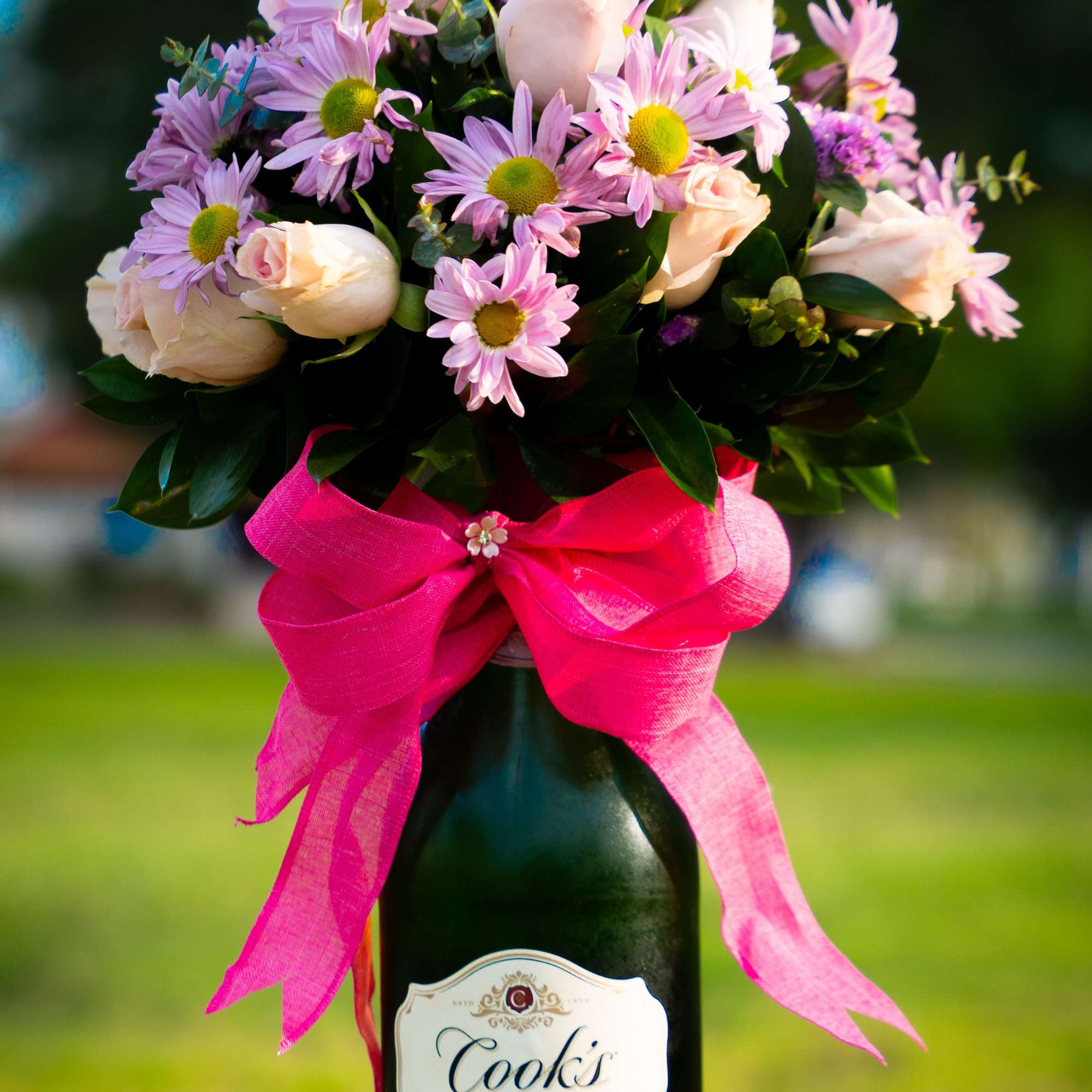 A perfect pair-- a beautiful bouquet wrapped around a bottle of fine