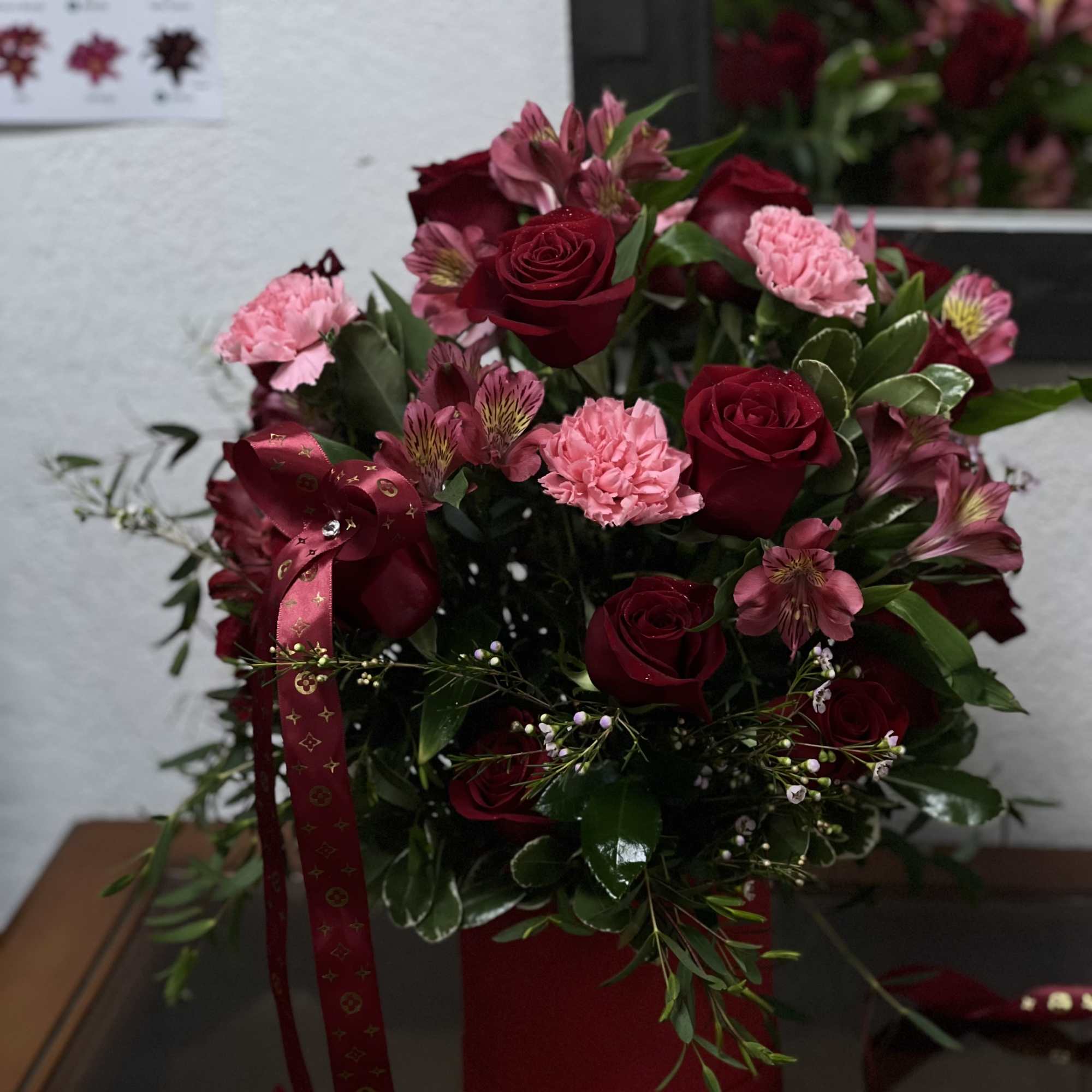 Red with shades of pink a perfectly compose piece
with roses alstromeria and