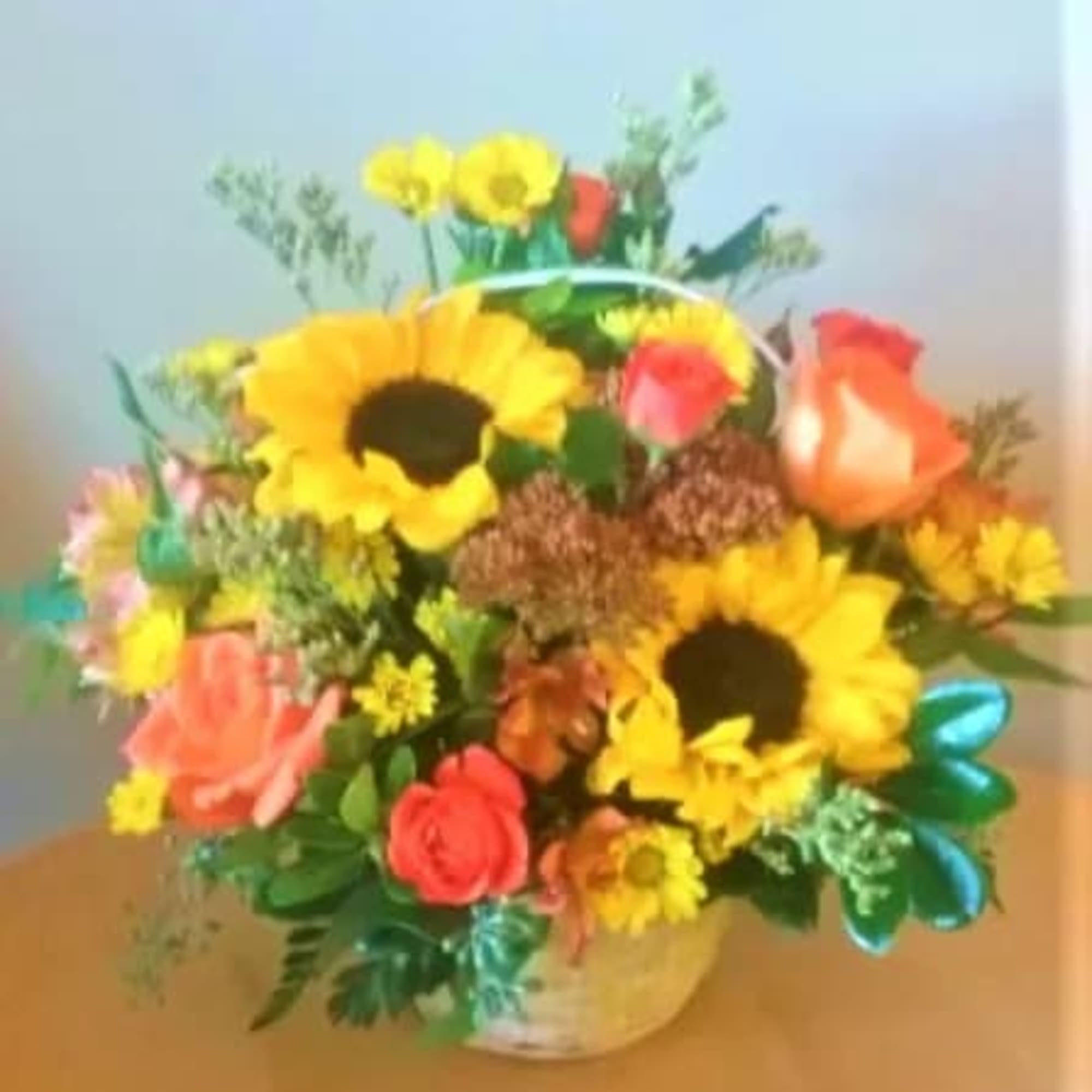 A basket of beautiful sunflowers,orange spray roses,bright yellow daisies and more.Just the