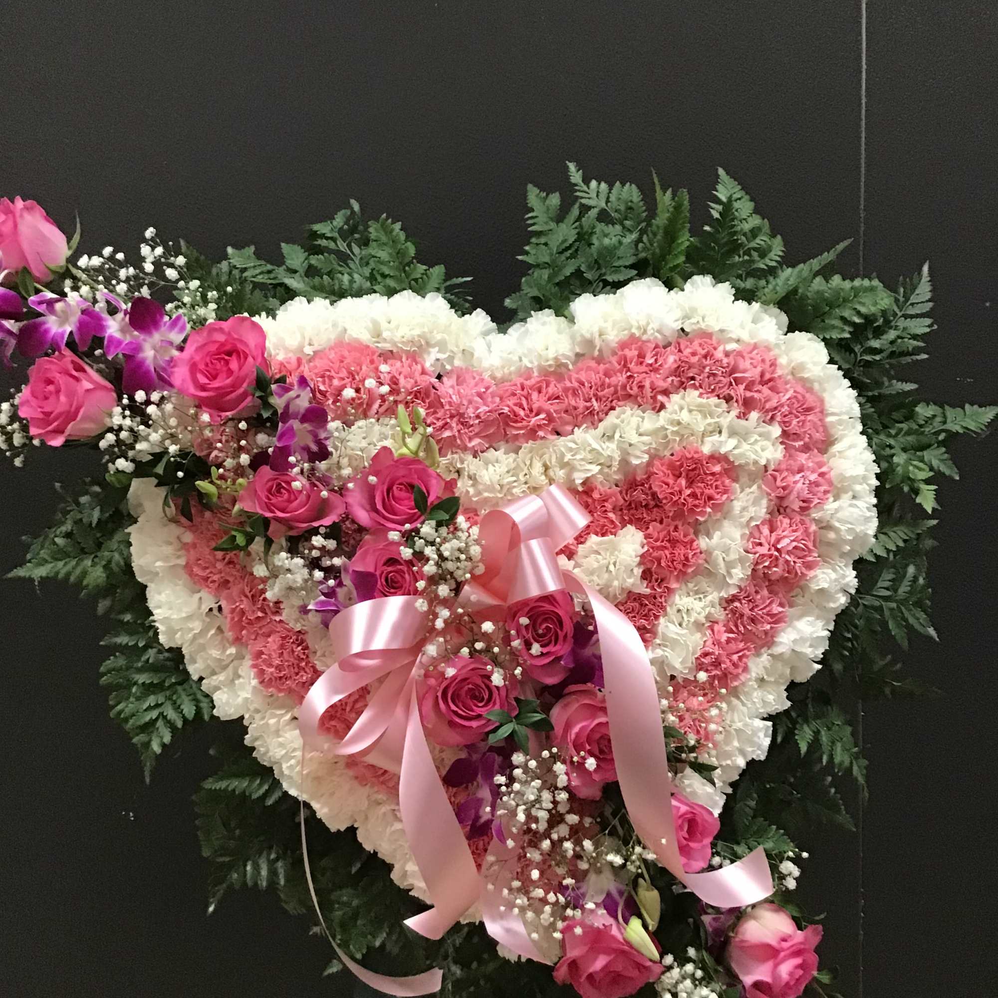 This arrangement make with pink and white carnations and lavender roses 