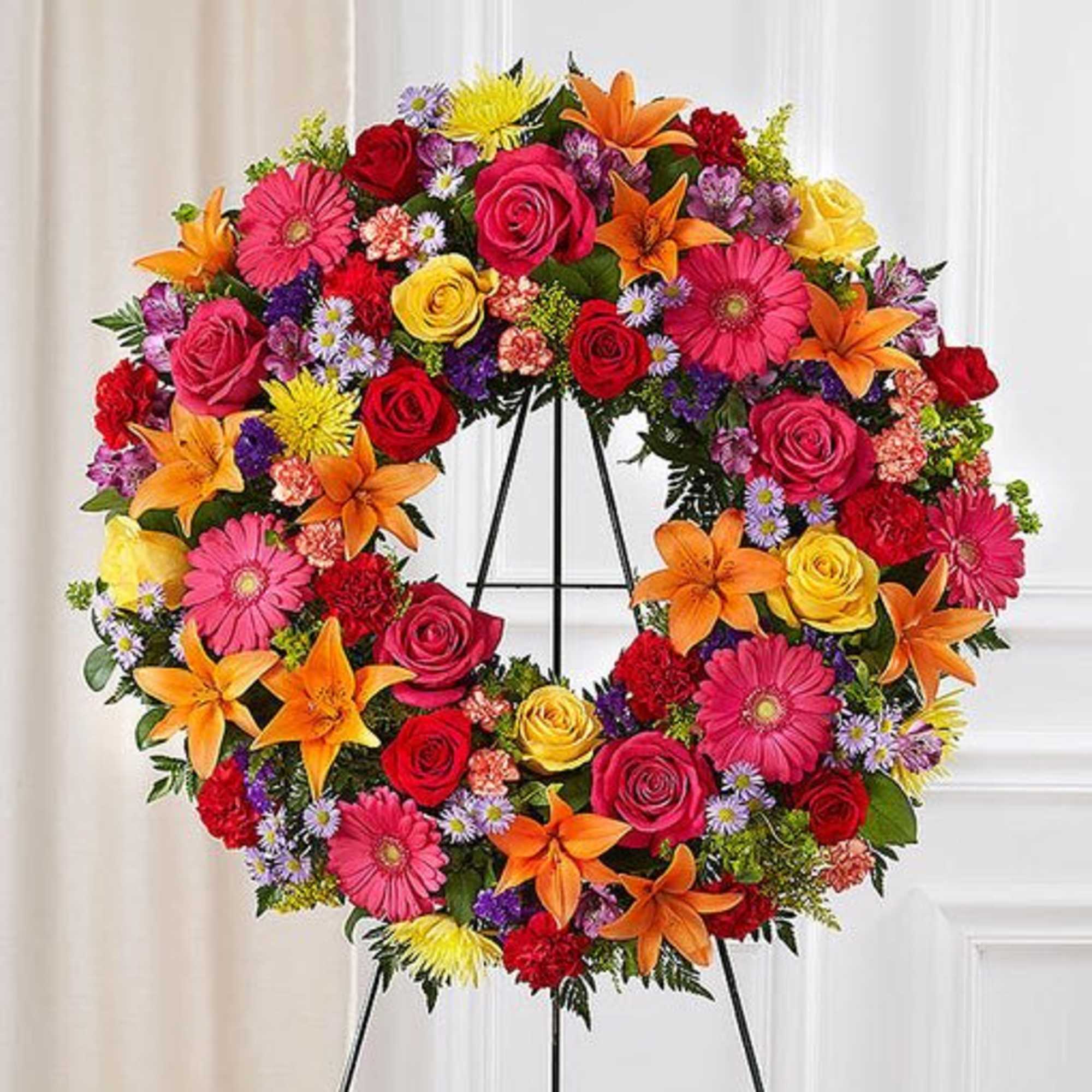 Standing wreath arrangement with red roses and carnations; orange Asiatic lilies and