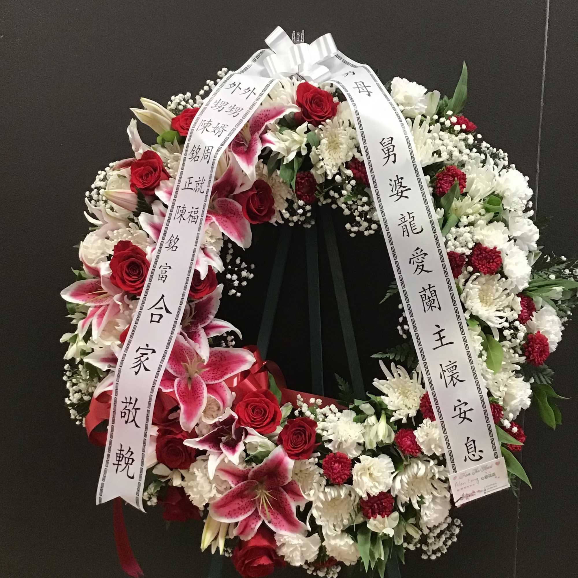 This beautiful wreath make with pink lilies , red roses, and white