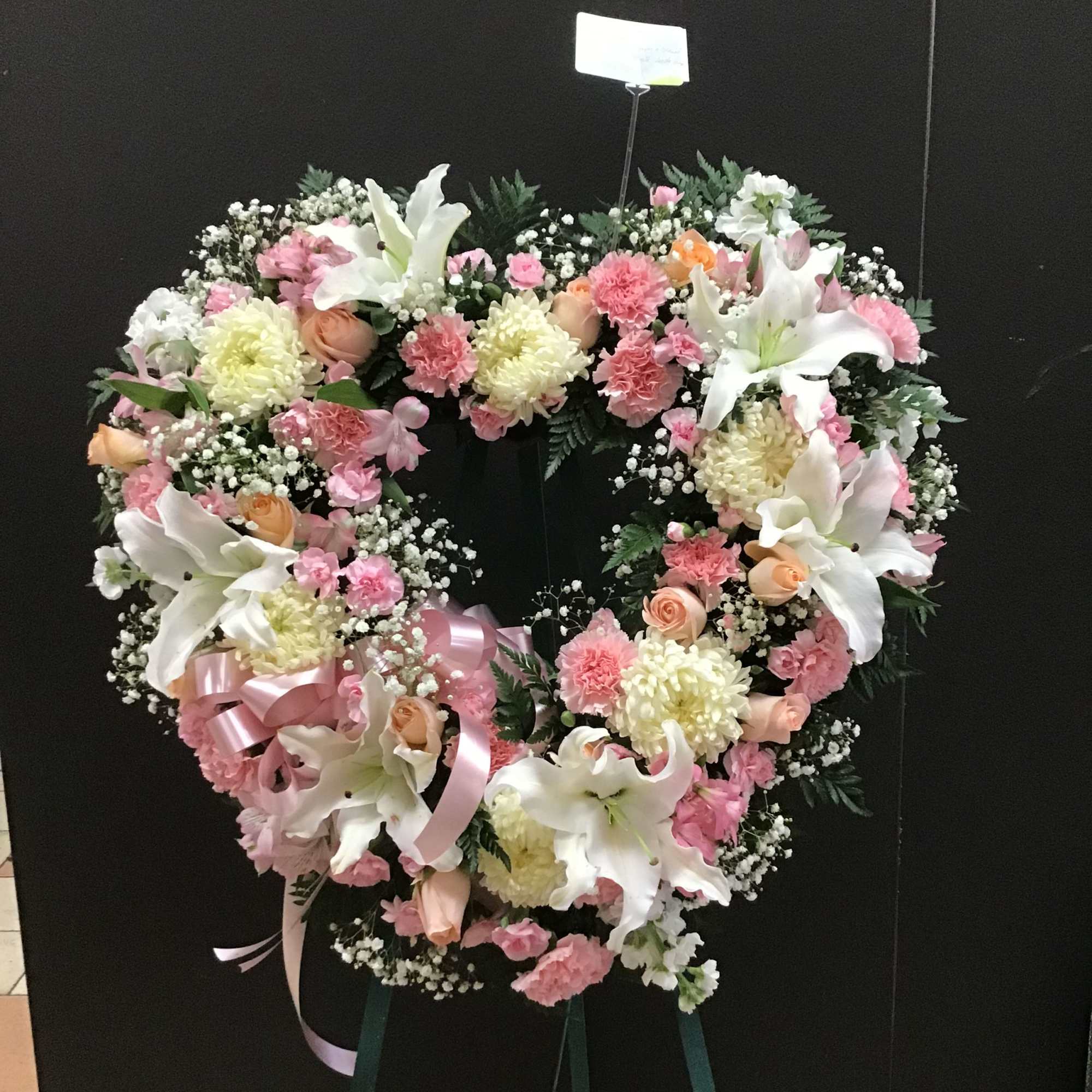 This Standing open heart make with white lilies, peach roses, and pink