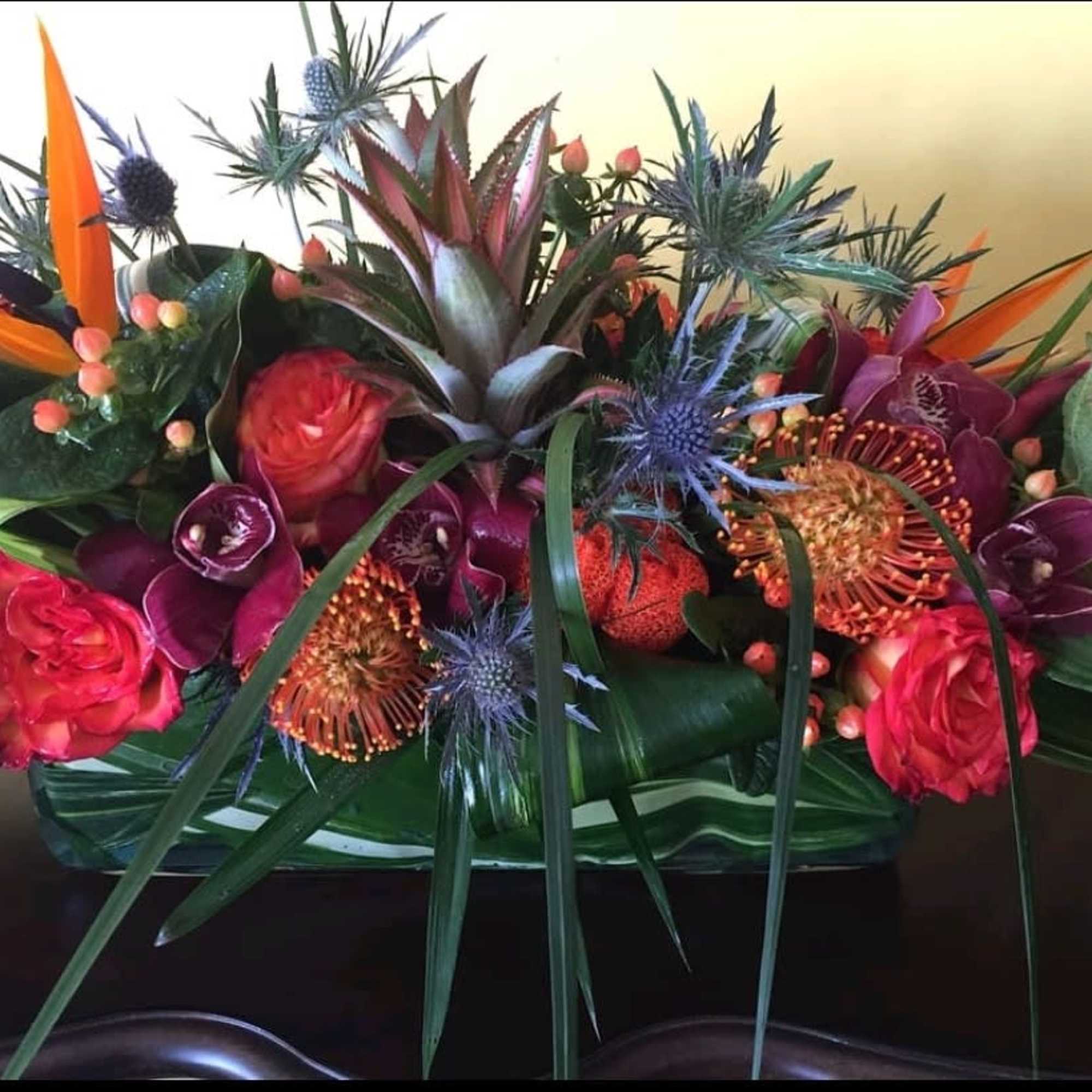 Rectangular glass container covered with tropical leaves filled with seasons best tropical