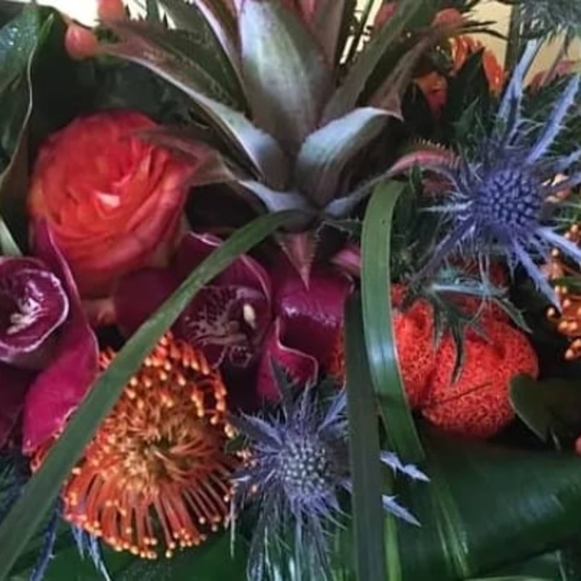 Rectangular glass container covered with tropical leaves filled with seasons best tropical