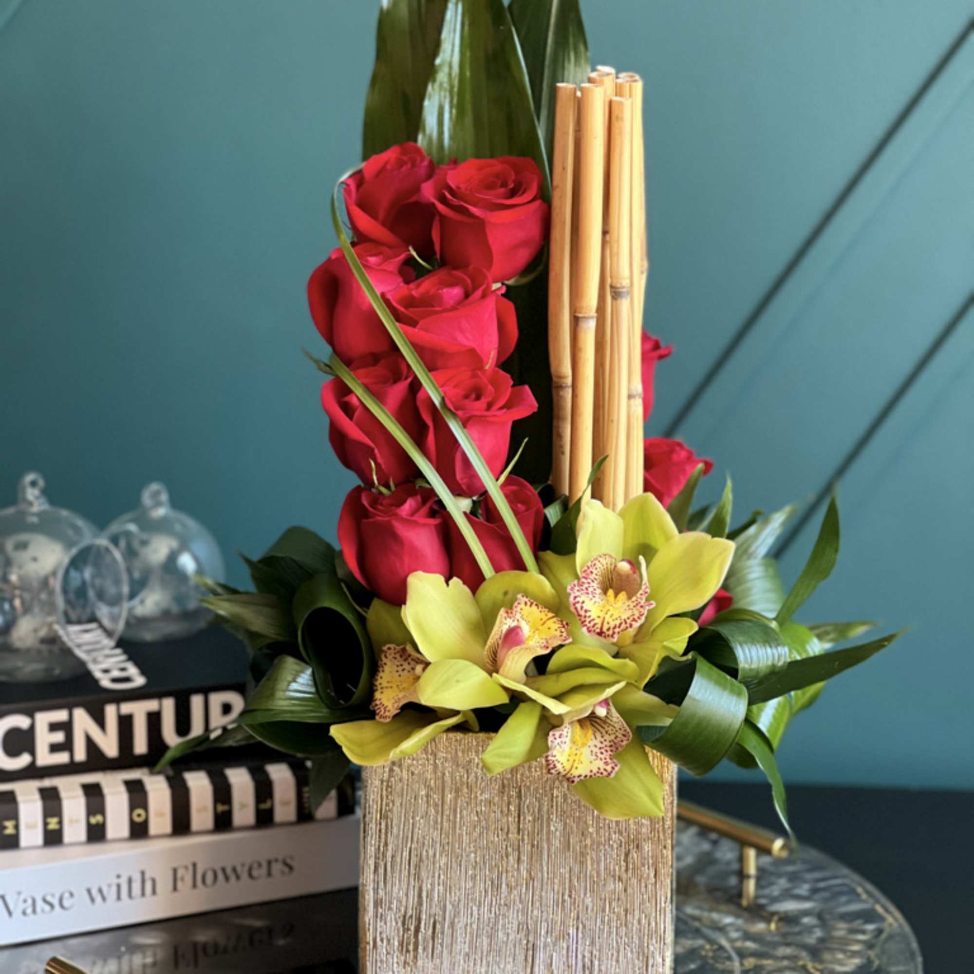 Dozen red roses and cymbidium orchids in gold vase 