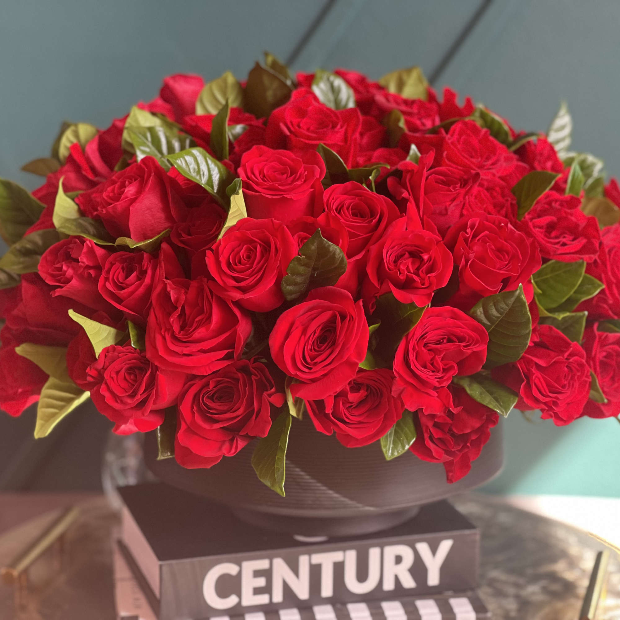 100 red roses in modern black vase 
